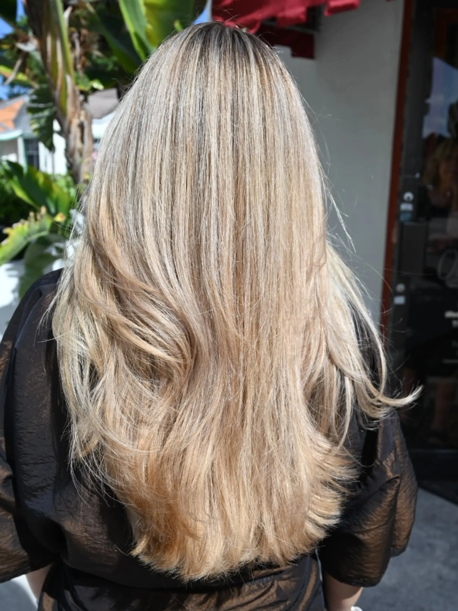 Long layered hair with fine, bright blonde highlights blended throughout a natural base, styled with soft movement. 1