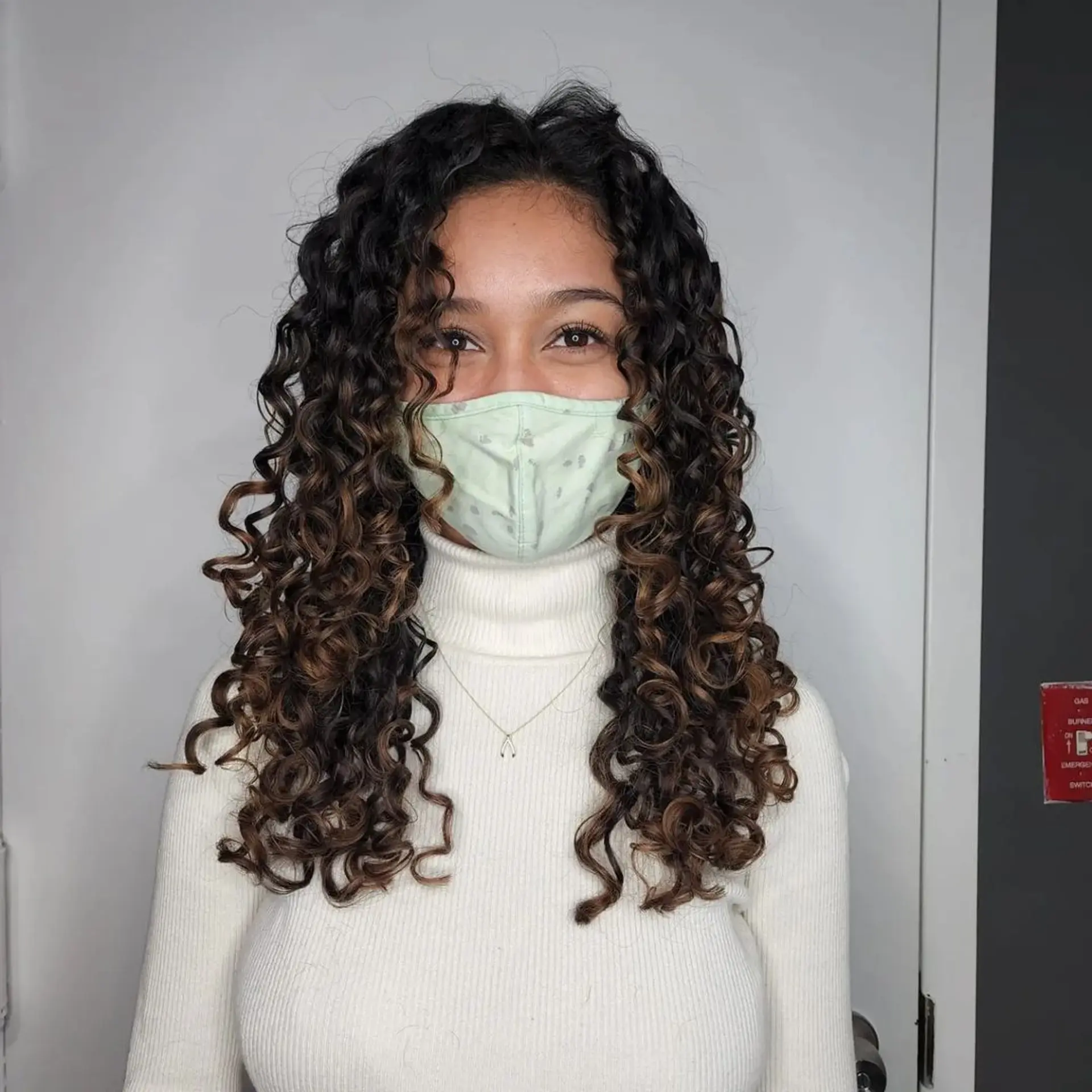 Long, curly hair with a gradient balayage effect from black to brown to blonde, featuring voluminous, defined curls with a healthy shine. 2