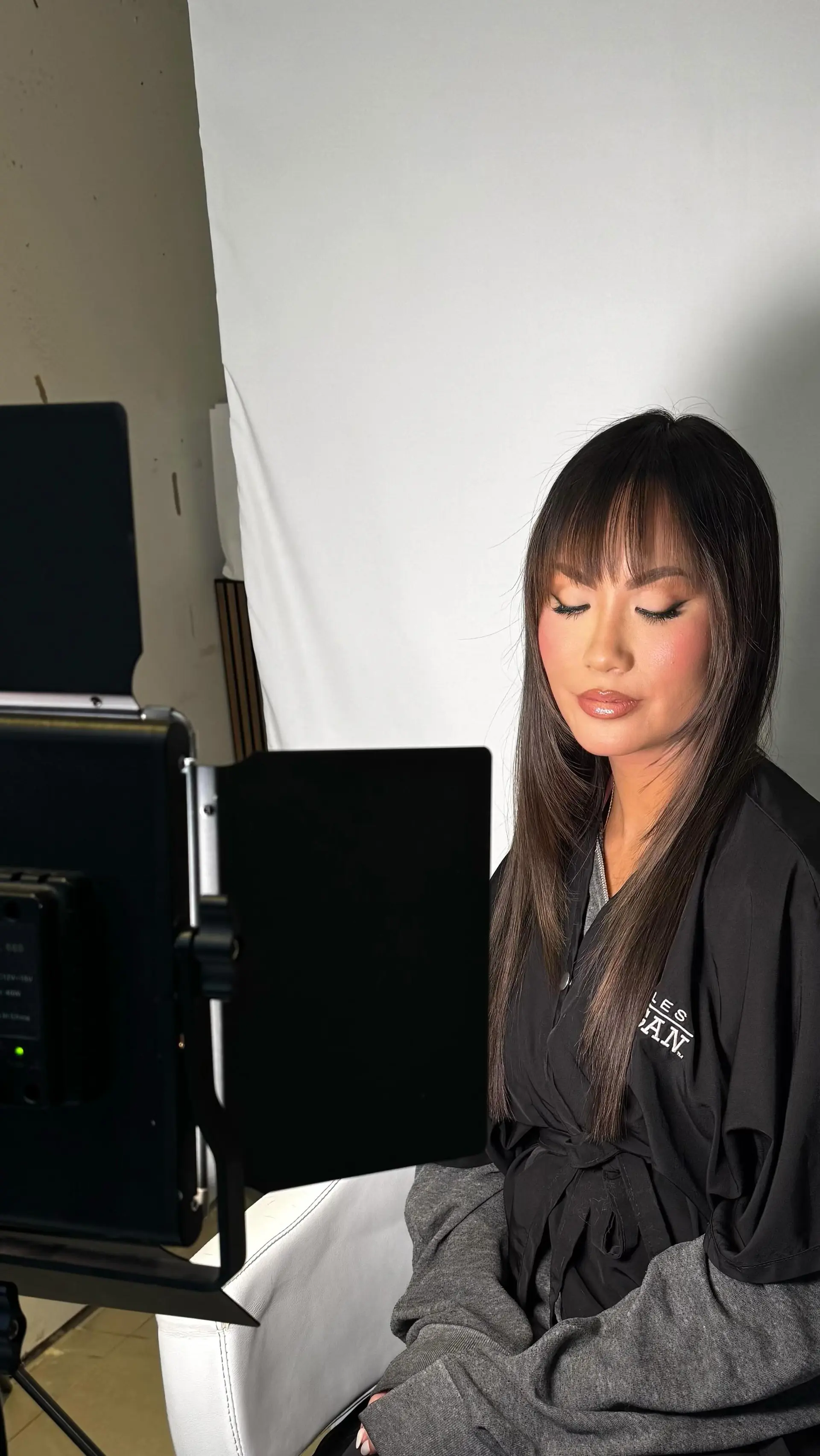 Smooth and straight dark brunette hair with soft, brow-skimming wispy bangs and subtle face-framing layers. 1