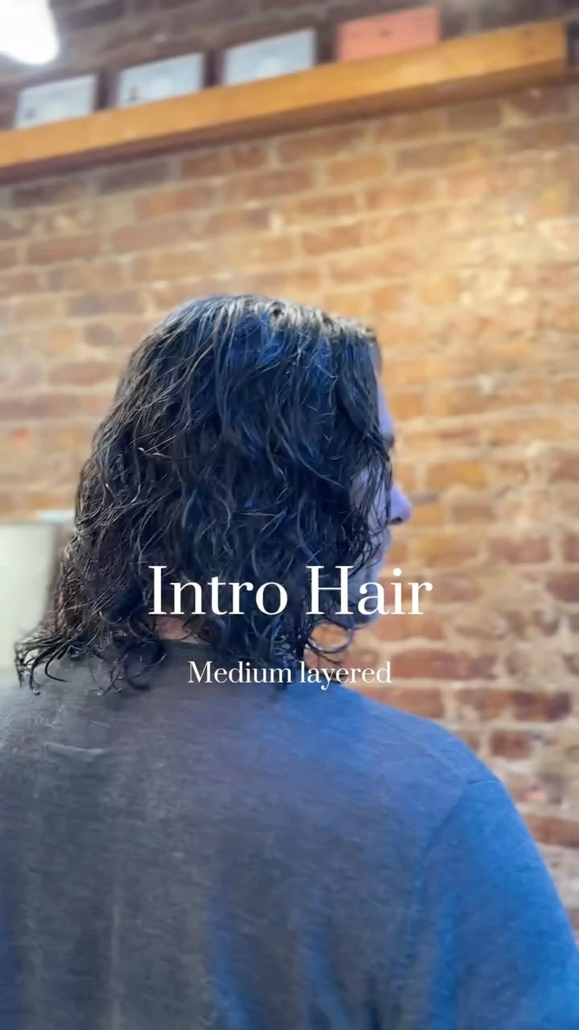 Medium-length textured haircut with natural wet-look waves falling gently around the neck and shoulders. 1