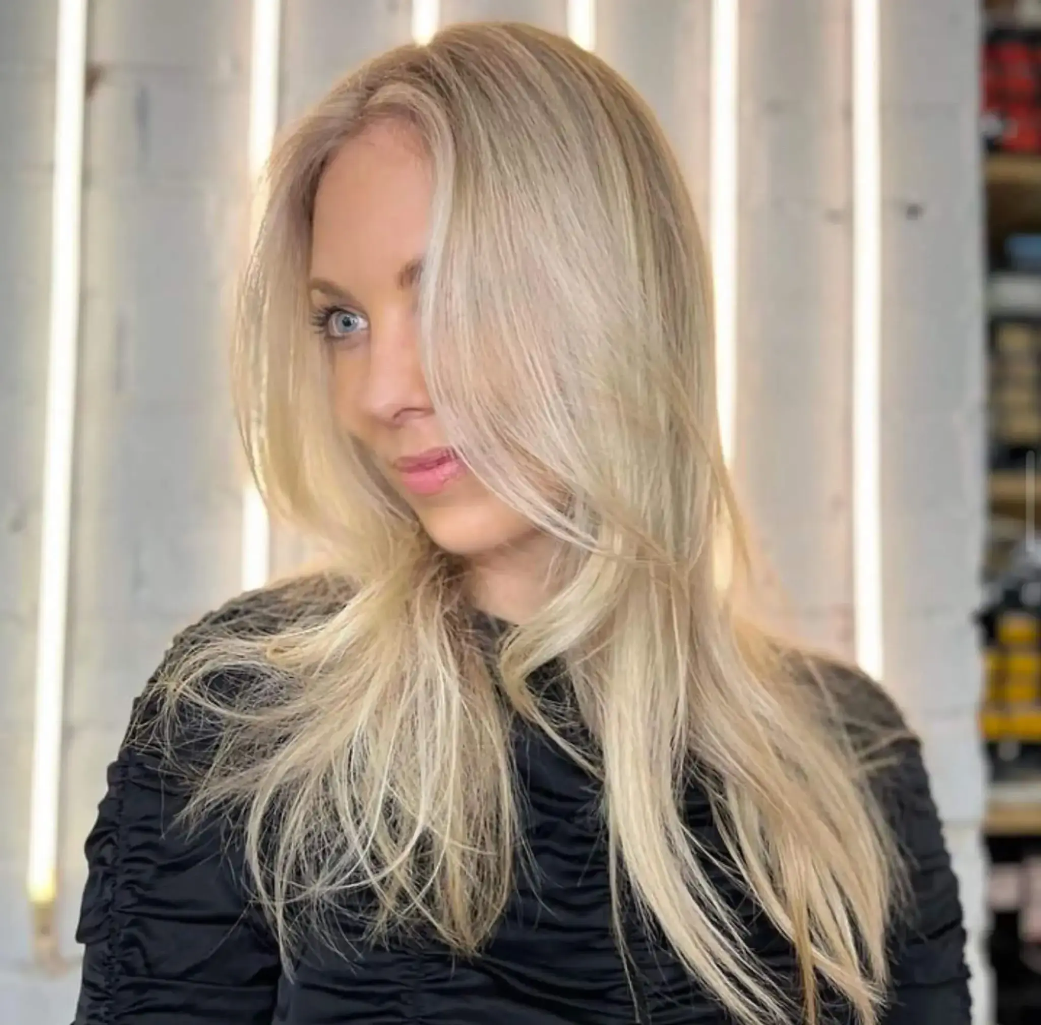 Long, straight blonde hair with soft layers and a side part. Features face-framing strands and a natural shine.