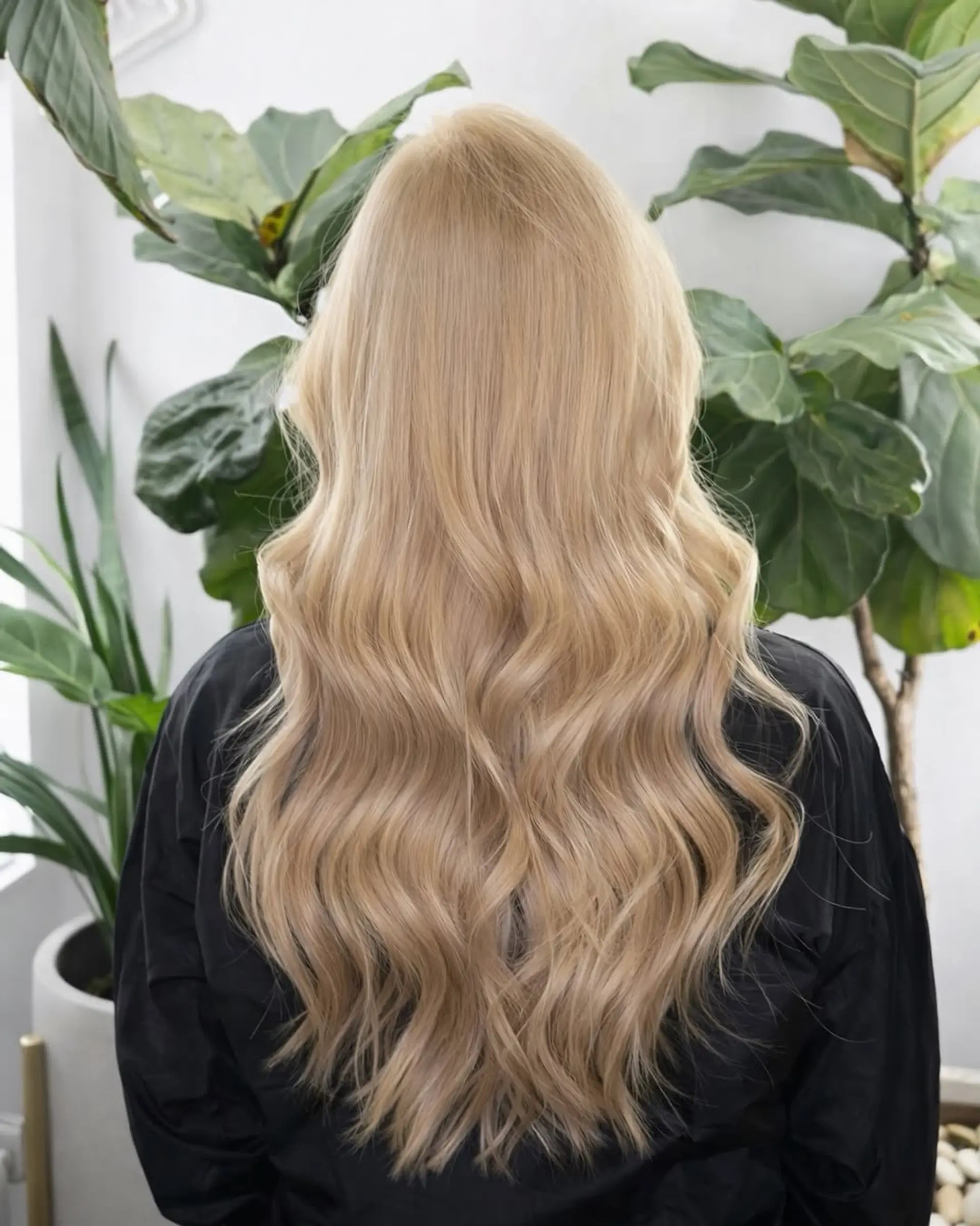 Long, flowing hair styled into soft, voluminous beach waves that provide a natural and effortless look. 1