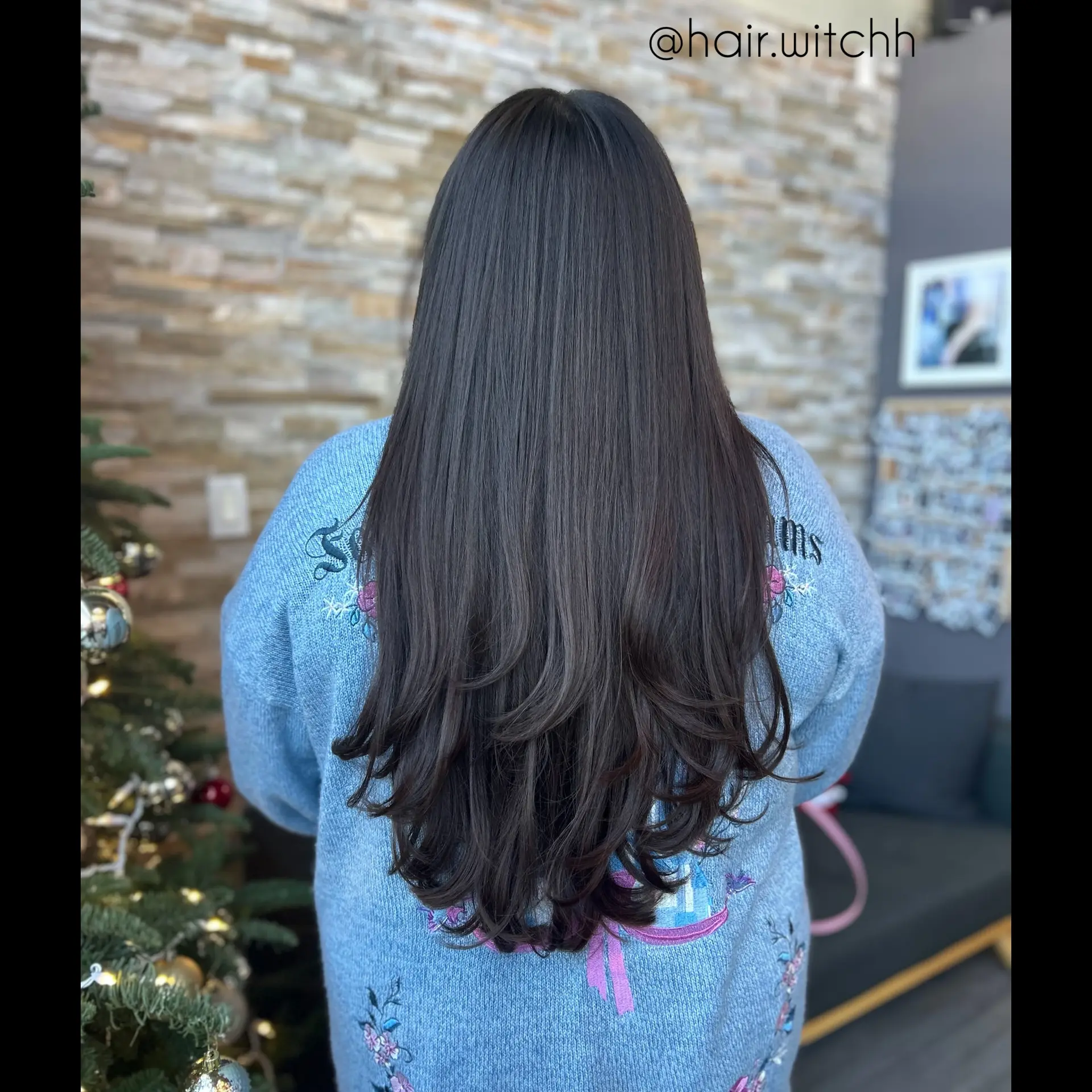 Very long, glossy dark hair styled straight with soft cascading layers and inward-curved ends. 1