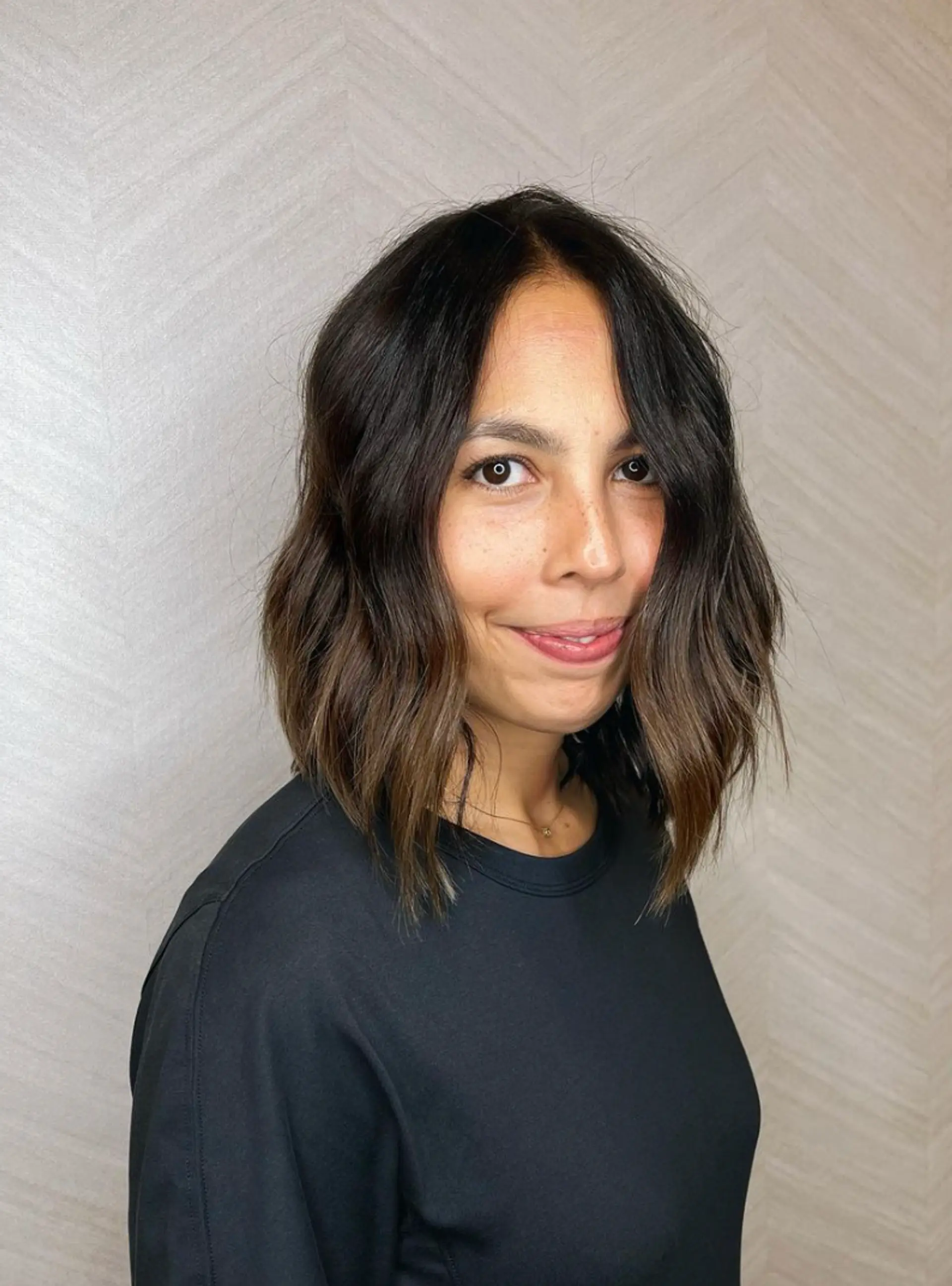 Medium-length chic wavy bob with dark brown hair and subtle highlights. Loose, natural waves with a side part and face-framing layers.

Cut and style by @juliamannino_hair
 3