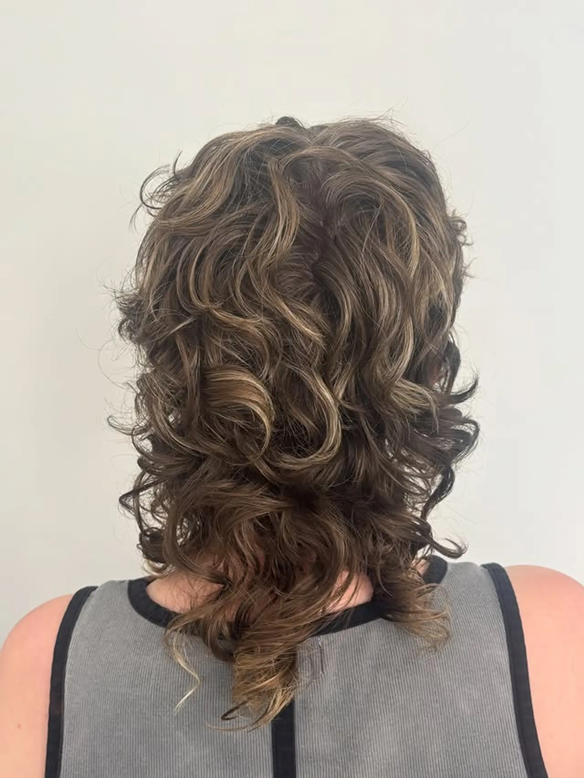 A curly shag with choppy layers and balayage highlights. 1