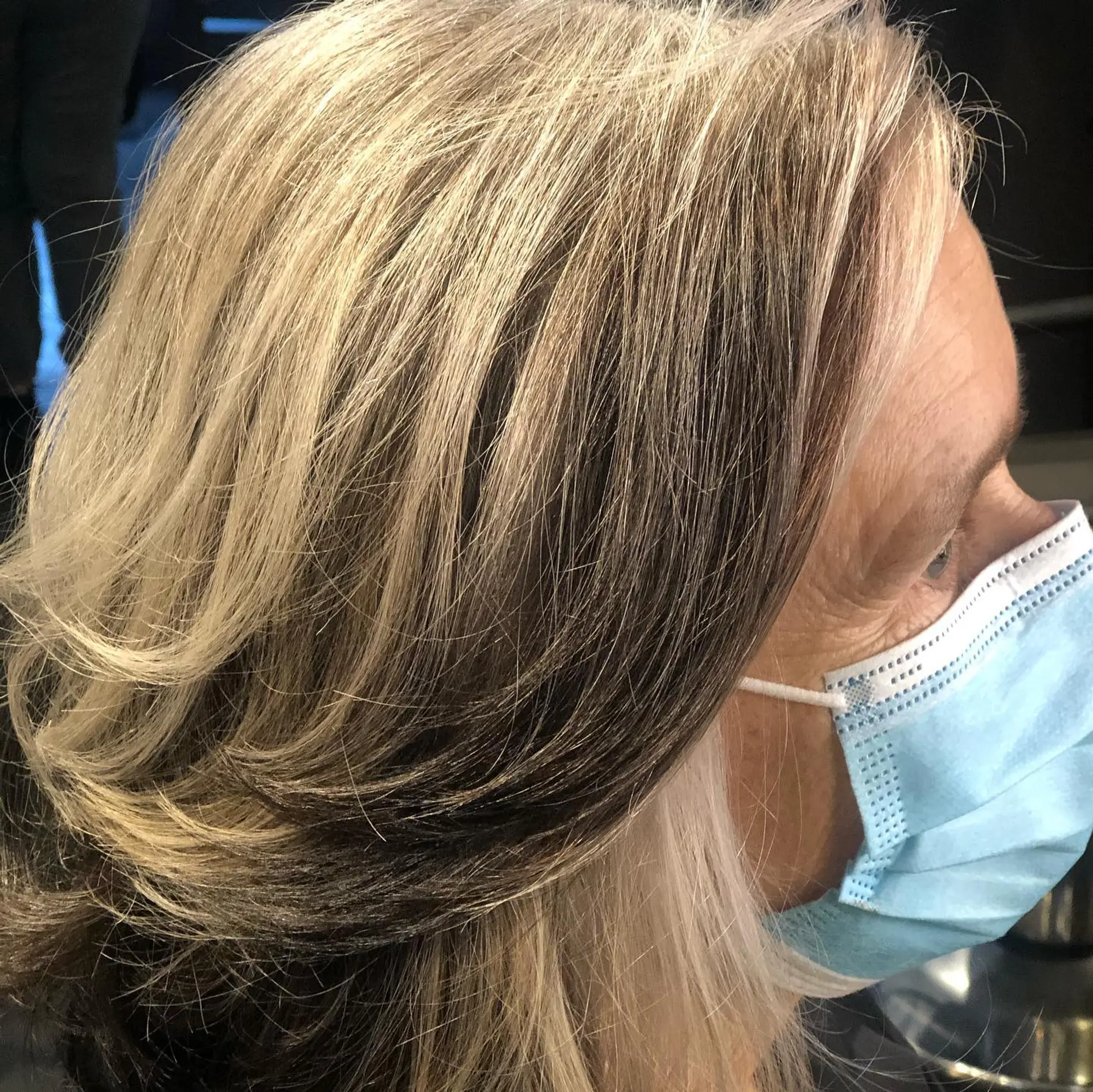 Medium-length feathered cut with dimensional blonde highlights and dark lowlights blended into gray hair. 1