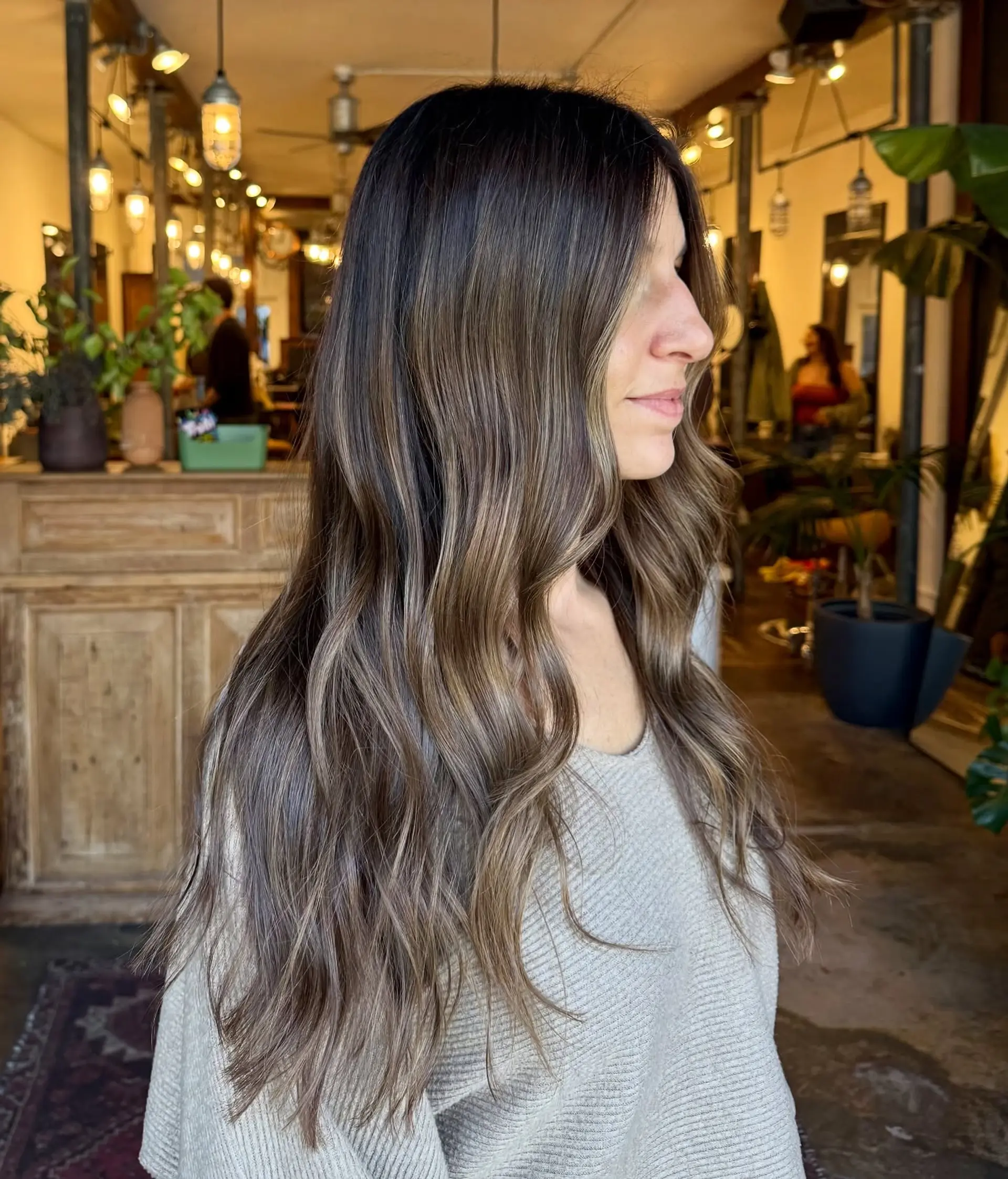 Long dimensional bronde waves featuring a soft shadow root melting into cool brown and blonde tones. 1