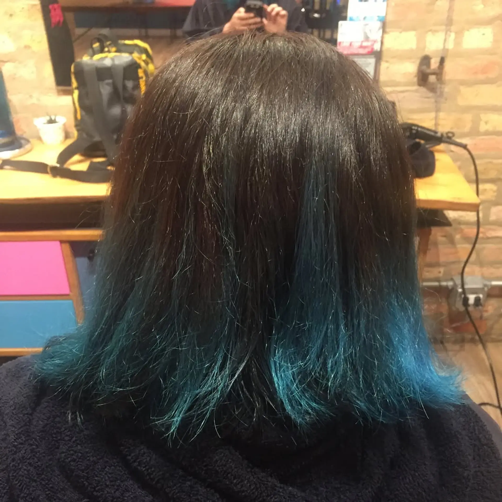 A striking ombre lob with a smooth transition from dark roots to vibrant teal ends. 1