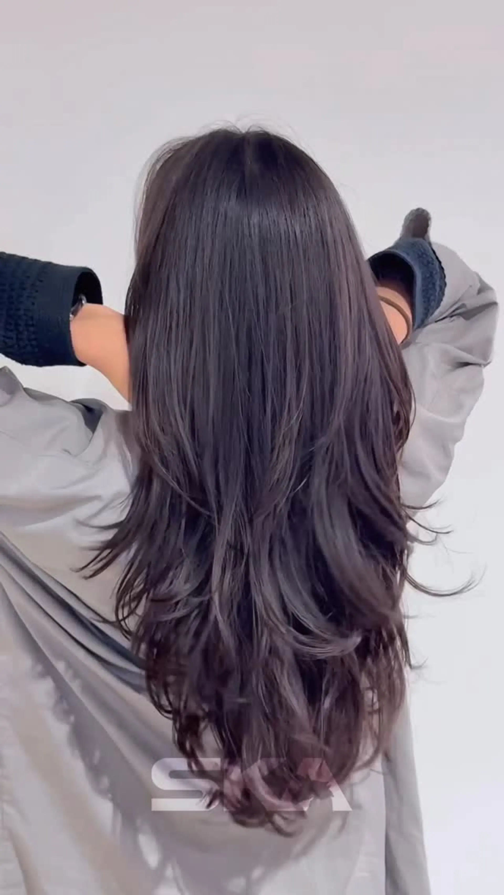 Long dark brown hair styled with heavy cascading layers, soft movement, and lightly textured ends tapering into a V-shape down the back. 1