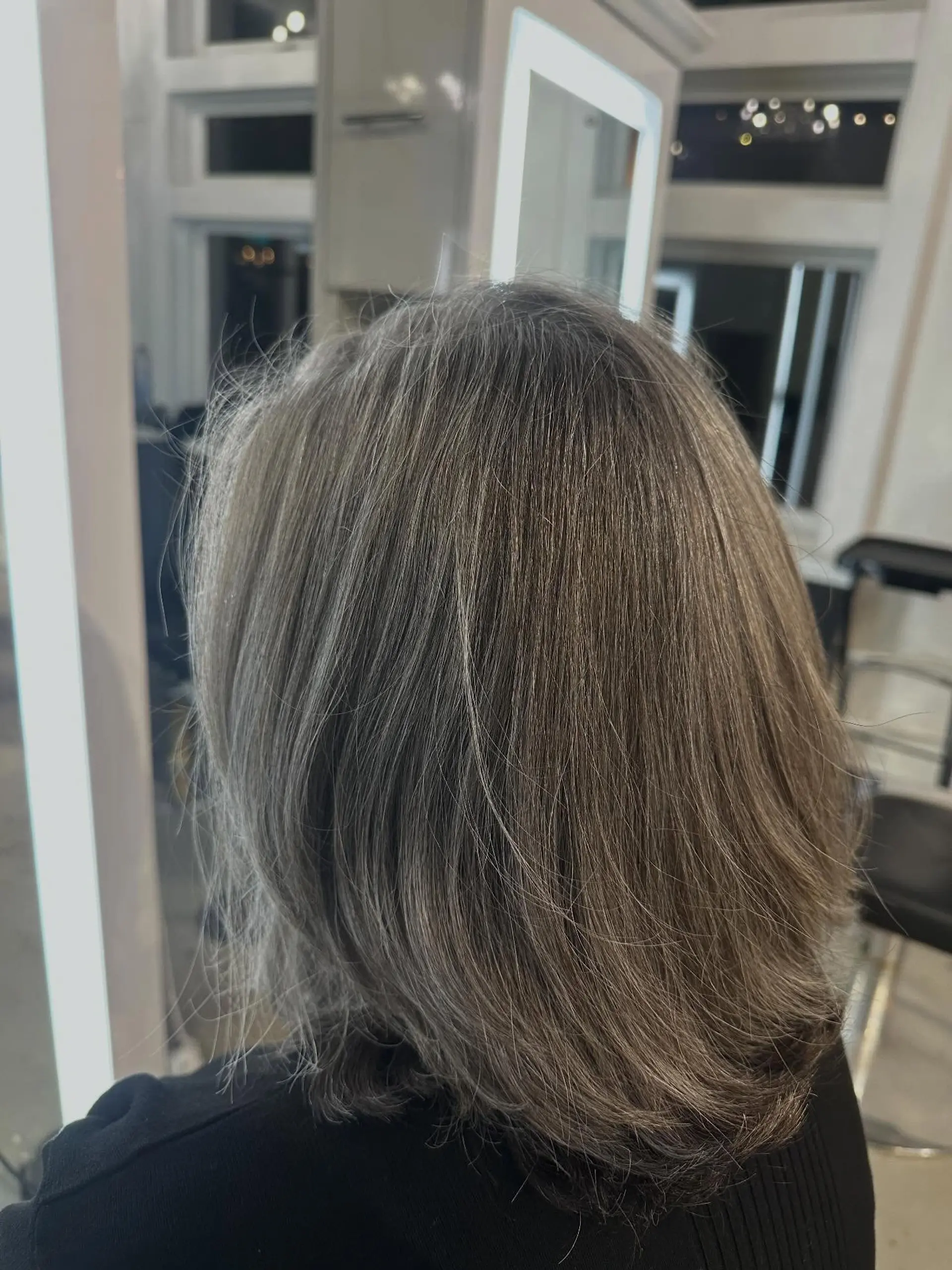 A rounded neck-length bob cut styled with a smooth blowout that turns under softly at the ends. 1