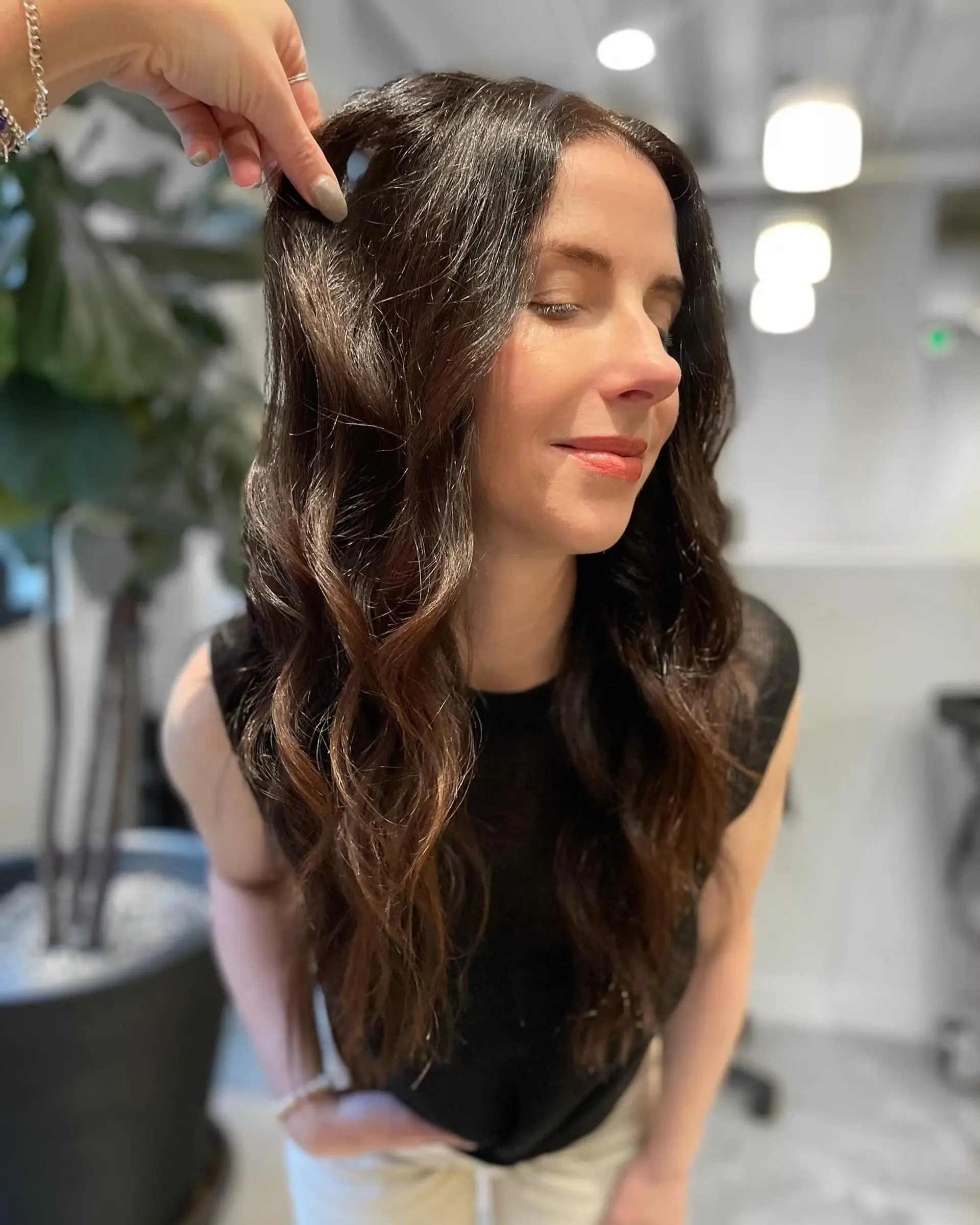 Long chocolate brunette hair featuring subtle dimensional tones, styled into soft, flowing waves. 1