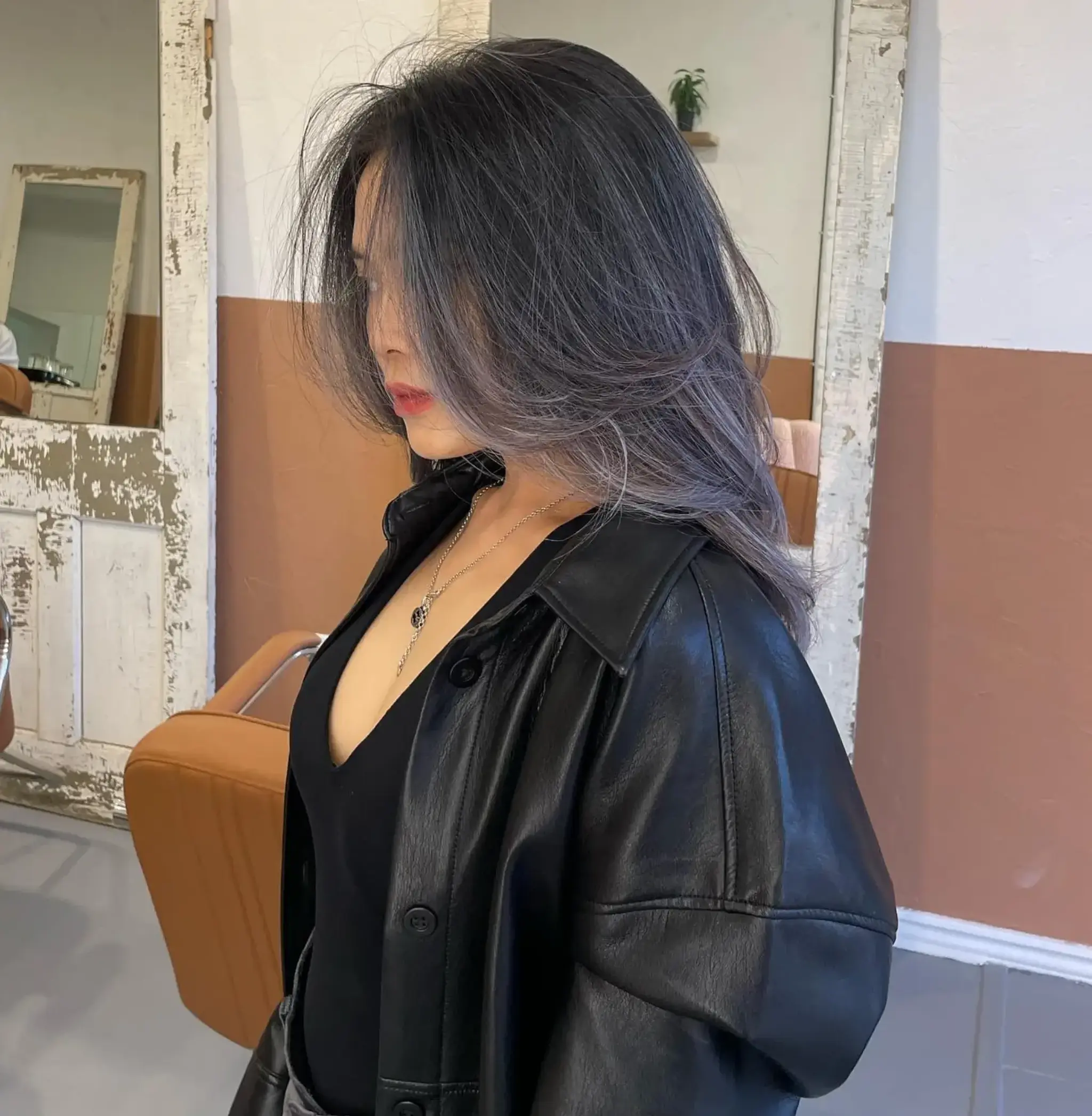 A long, wavy hairstyle with silver and ash tones, featuring layered, face-framing strands for added volume and movement.