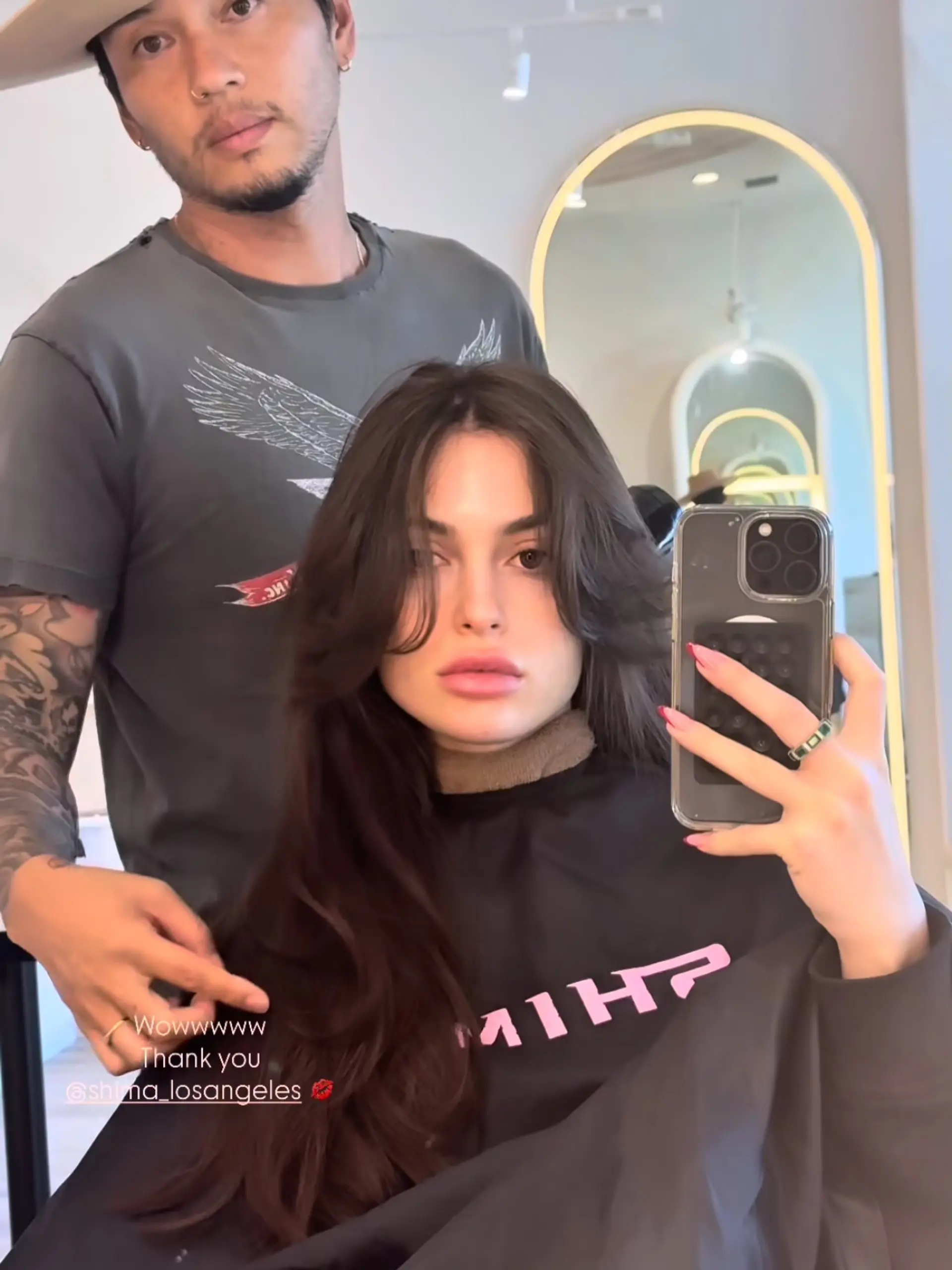 Long dark brown hair styled with voluminous butterfly layers and face-framing curtain bangs. 1