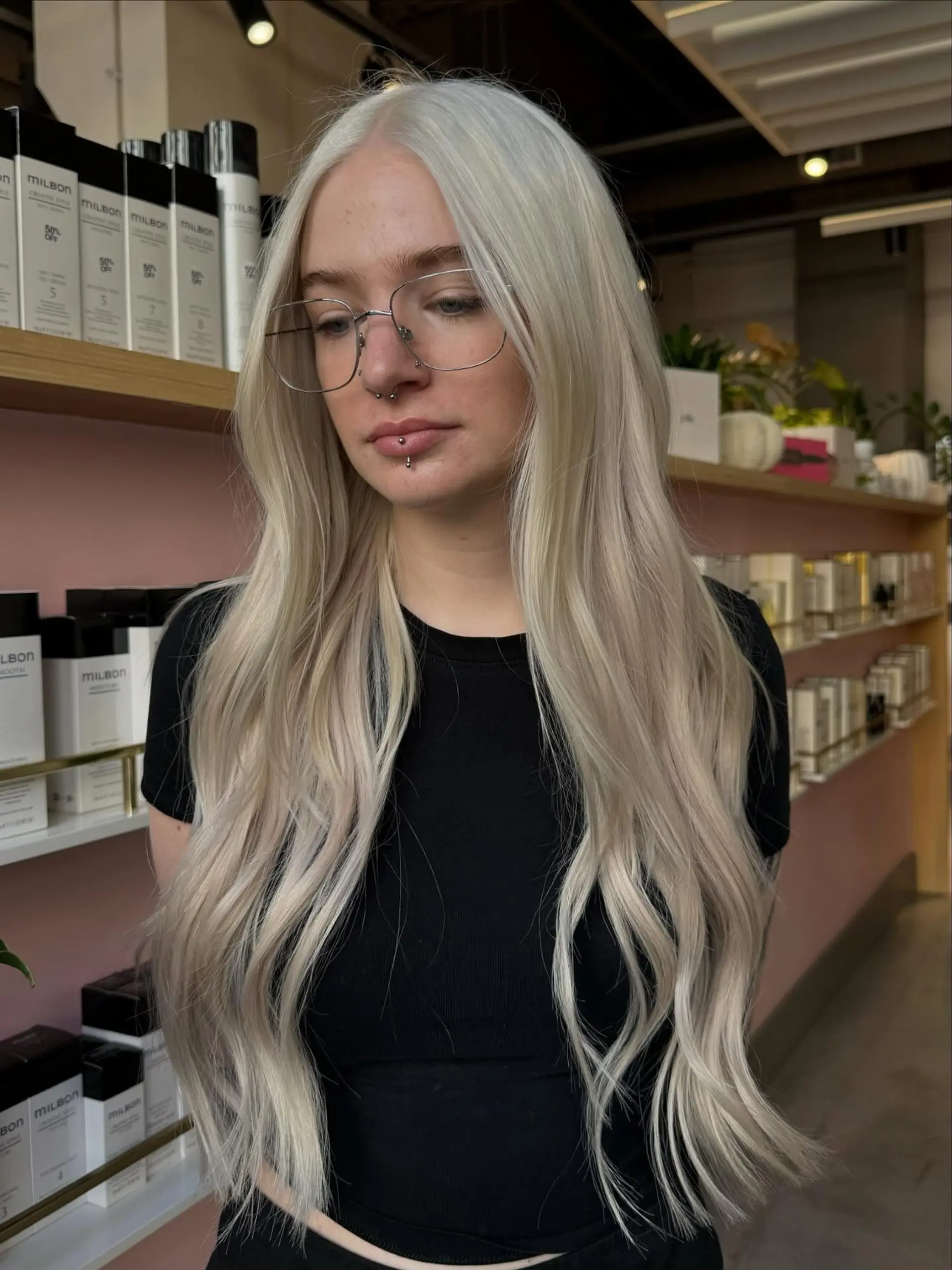 Extra-long icy platinum blonde hair styled into loose, gentle waves with a center part. 1