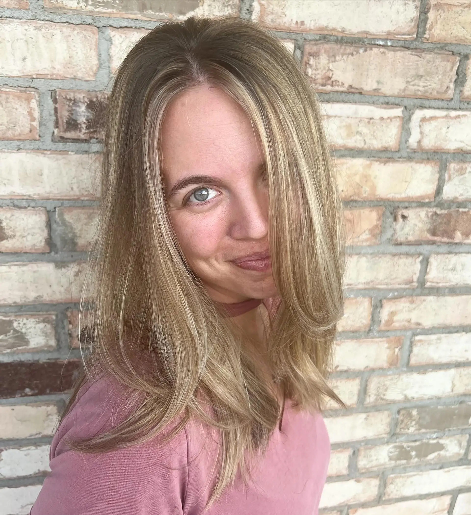 Medium-length smooth blowout featuring seamless blonde balayage with delicate face-framing highlights. 1