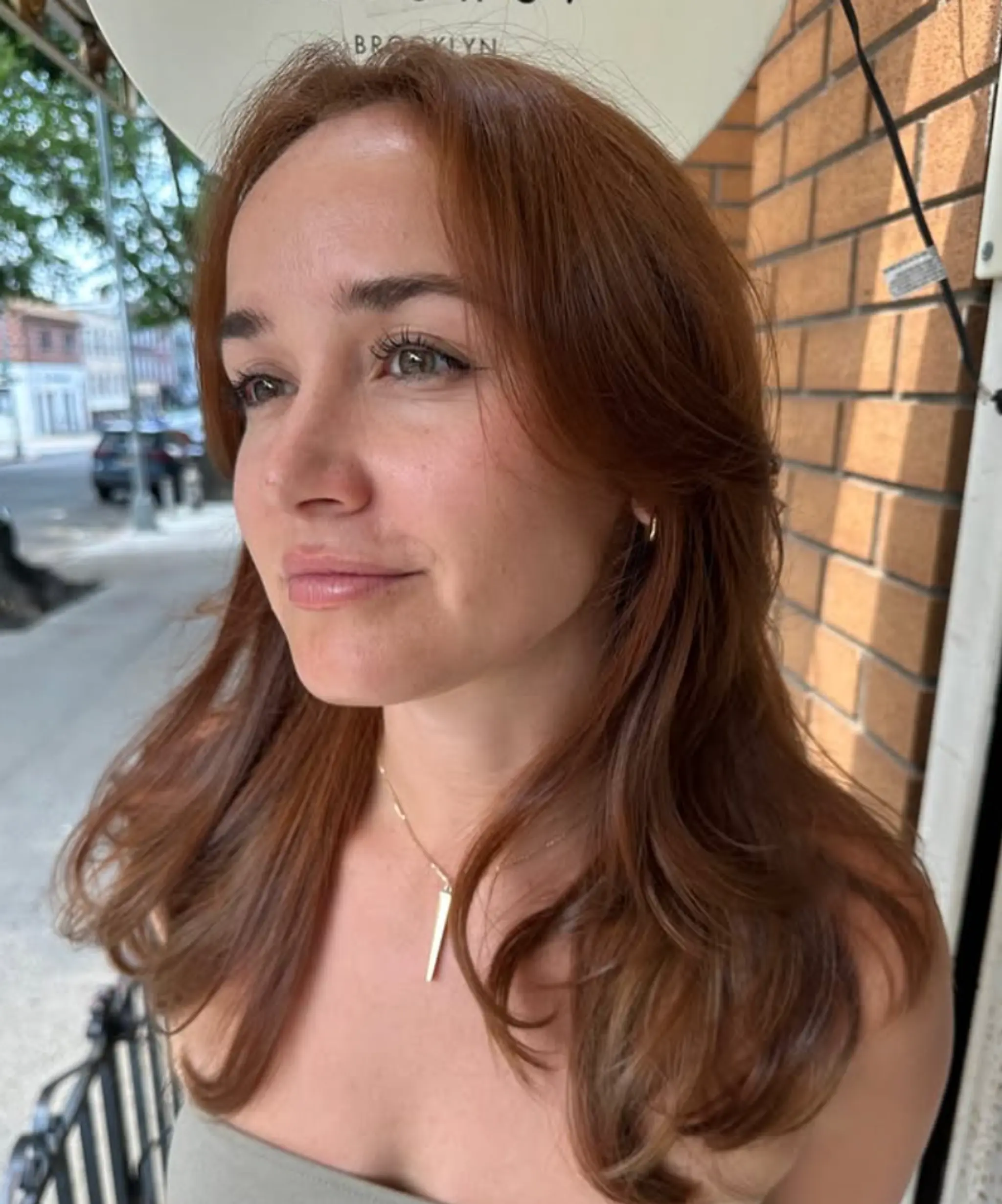 A long, wavy hairstyle featuring soft waves and face-framing layers in copper and auburn tones.