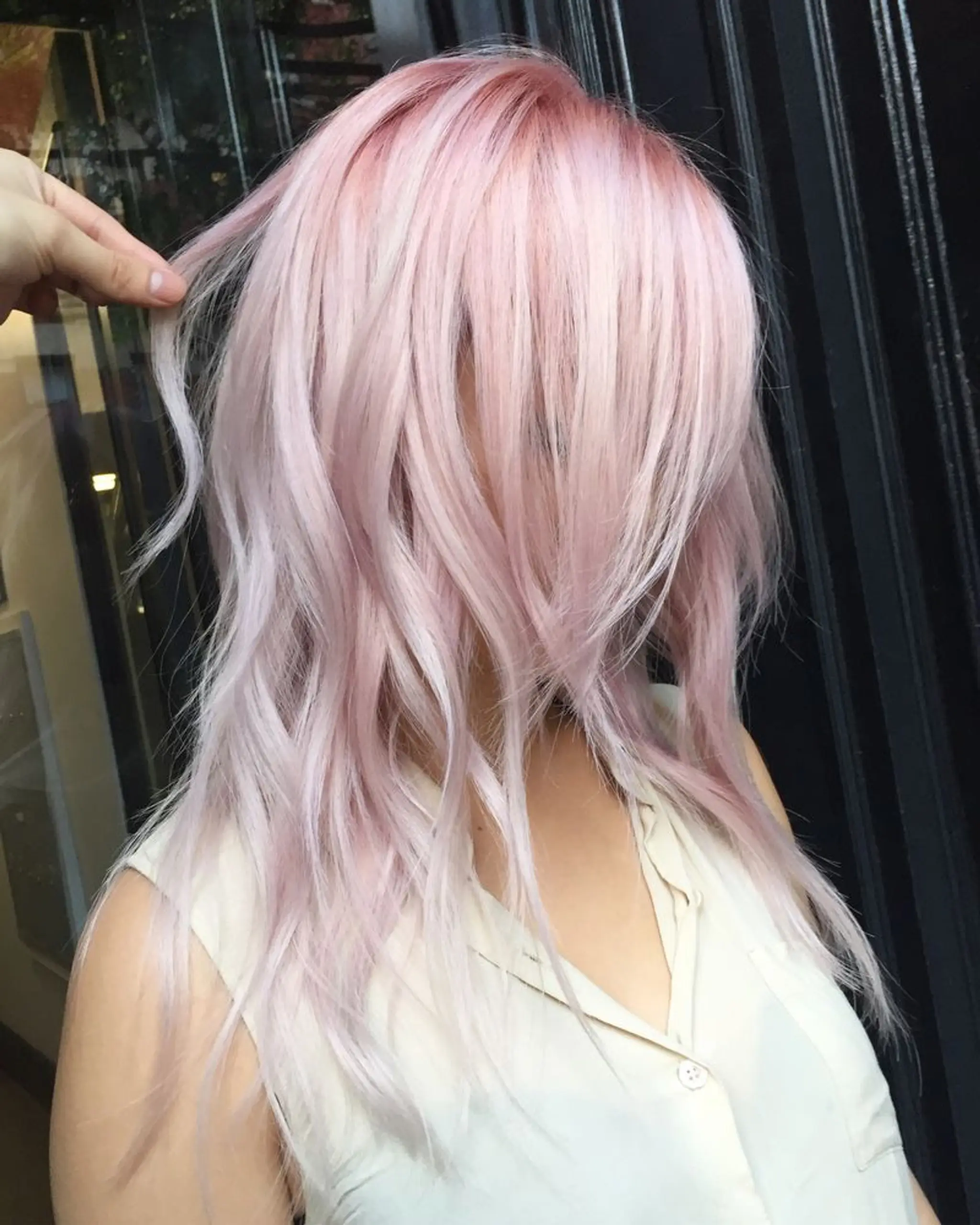 Long, pastel pink and platinum blonde hair with soft waves and layered cuts, featuring a subtle fringe.