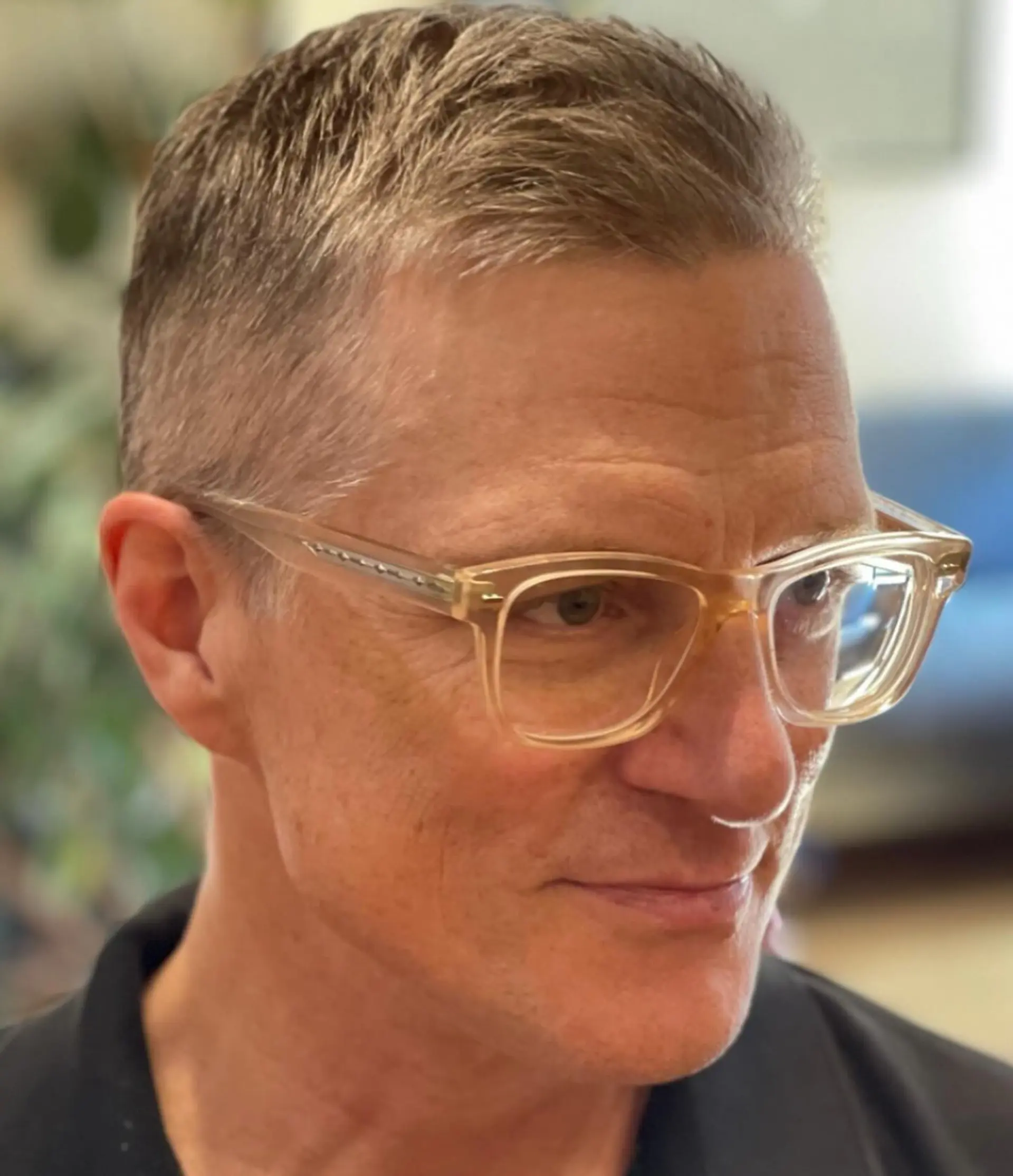 A short, tapered haircut, styled for a clean and professional look. 1