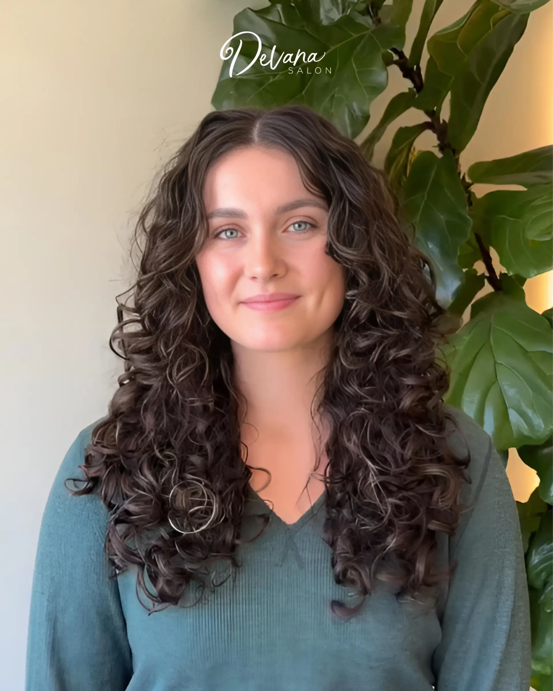 Long dark brown hair cut with textured layers to create voluminous, bouncy, and defined curls. 1