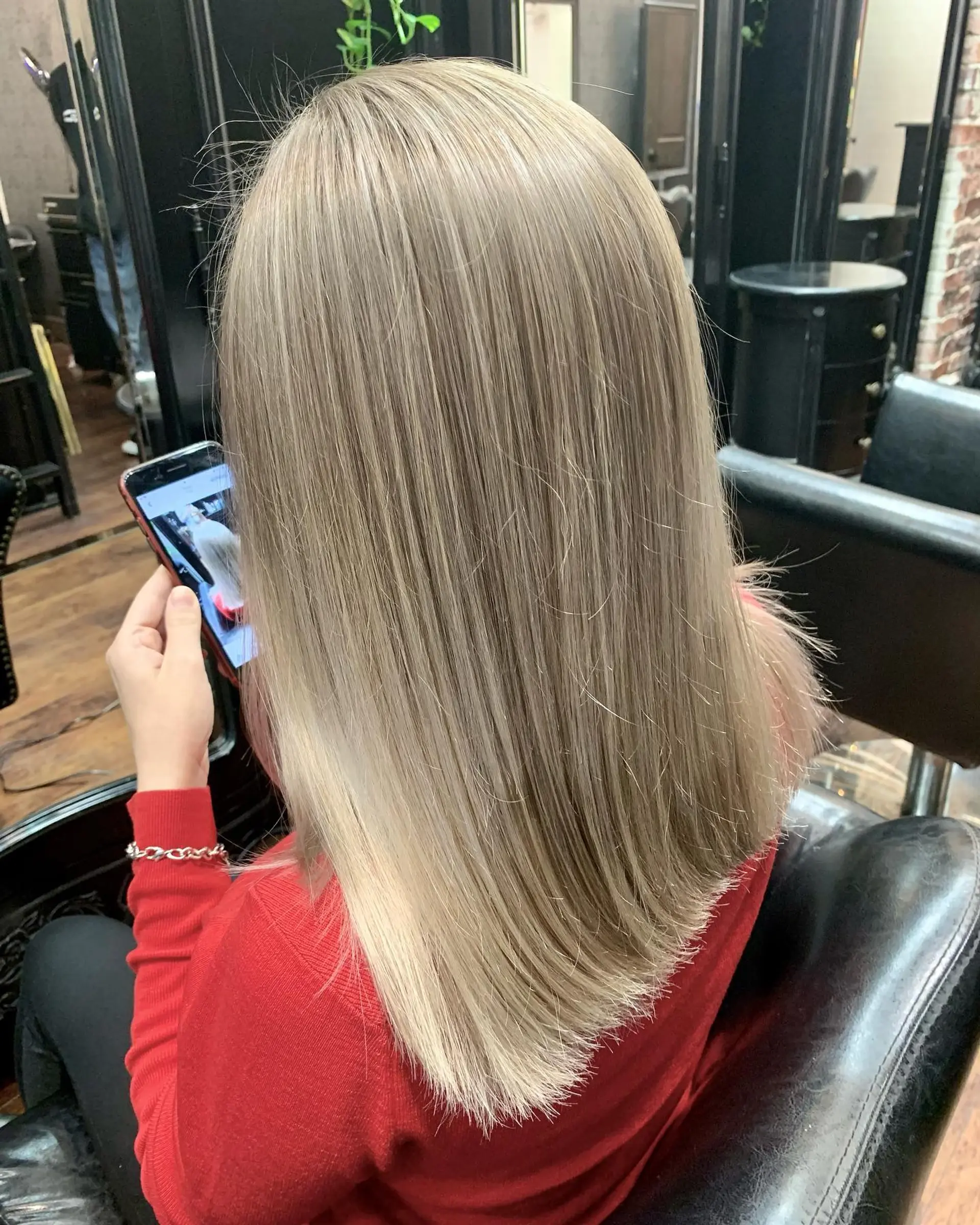 Medium-length straight hair styled sleek with seamless ash blonde highlights. 1