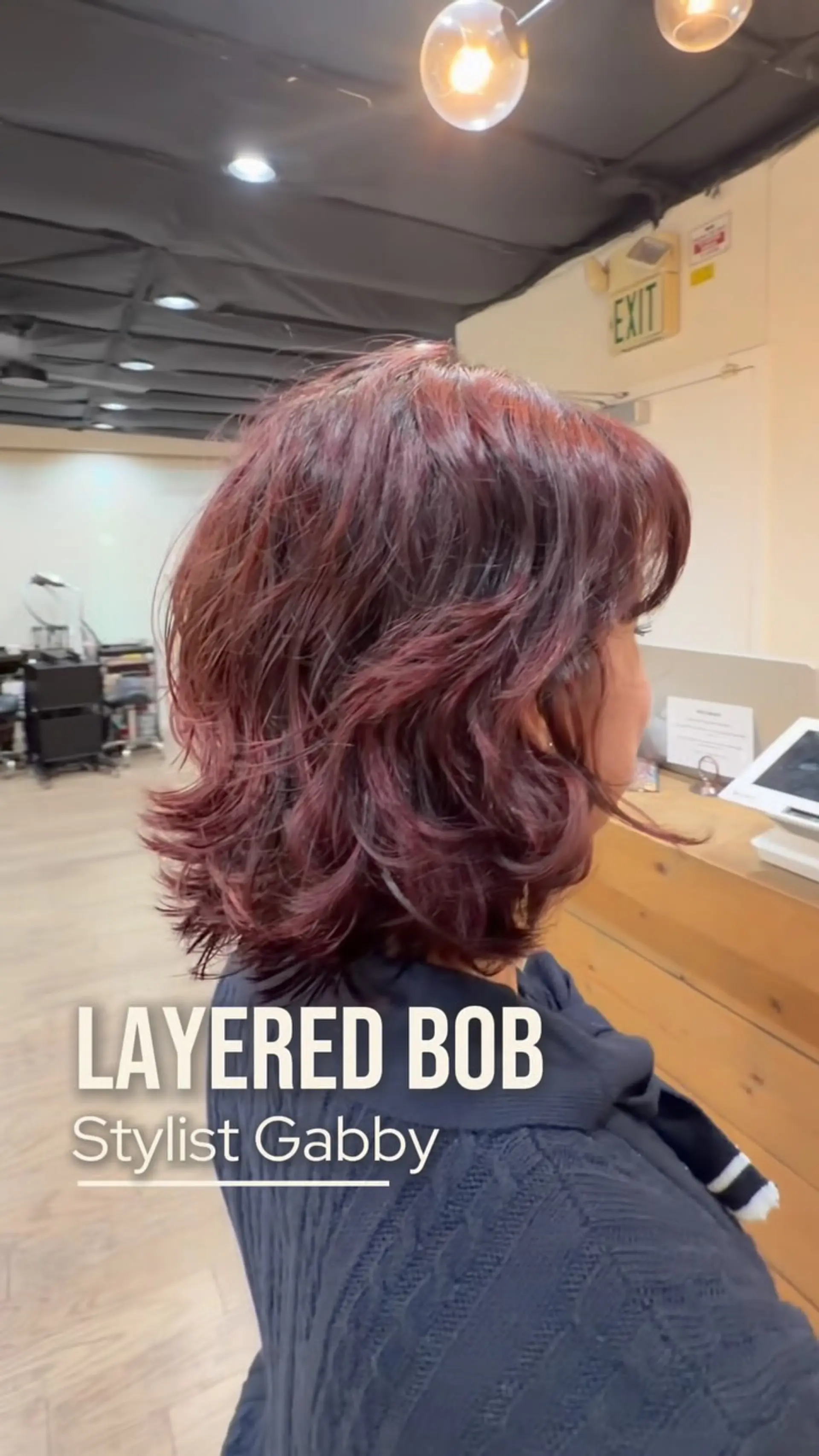 A textured layered bob with subtle outward flips and rich burgundy-red tones. 1