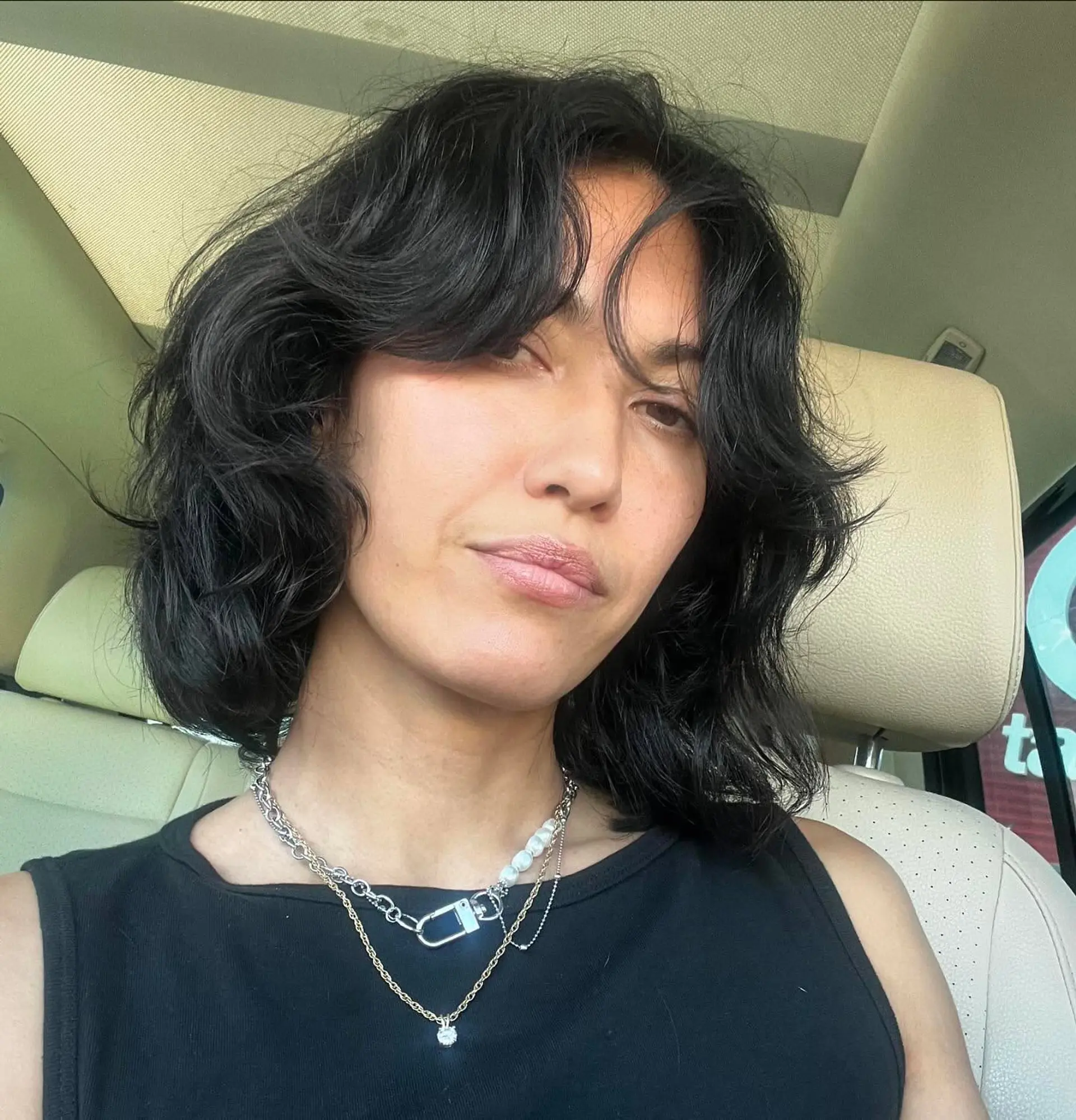 A textured shaggy bob featuring soft layers, subtle waves, and face-framing curtain bangs. 1