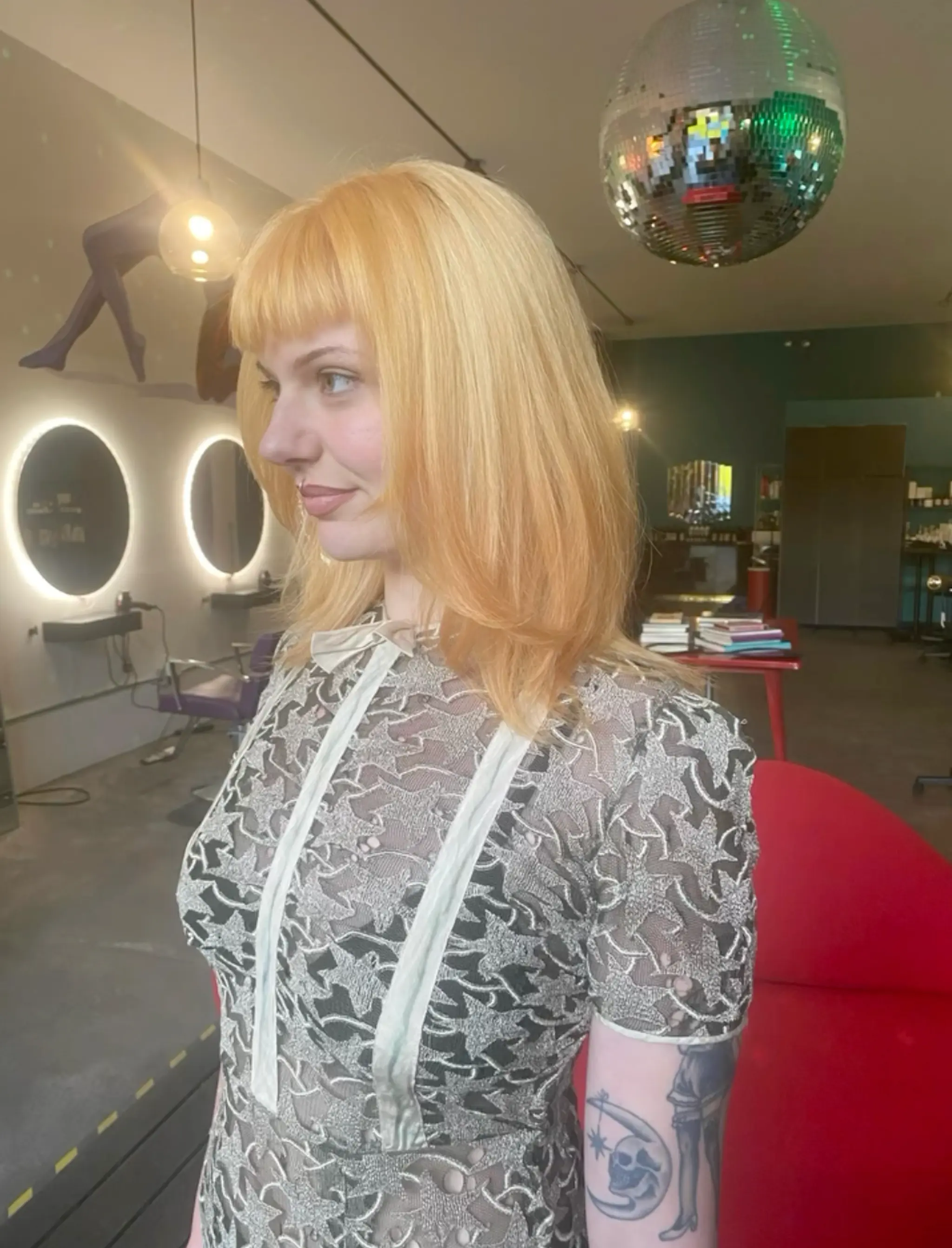 A medium-length, straight blonde hairstyle with blunt bangs and layered ends, exuding a retro vibe and warmth.

Peachy Haley Williams