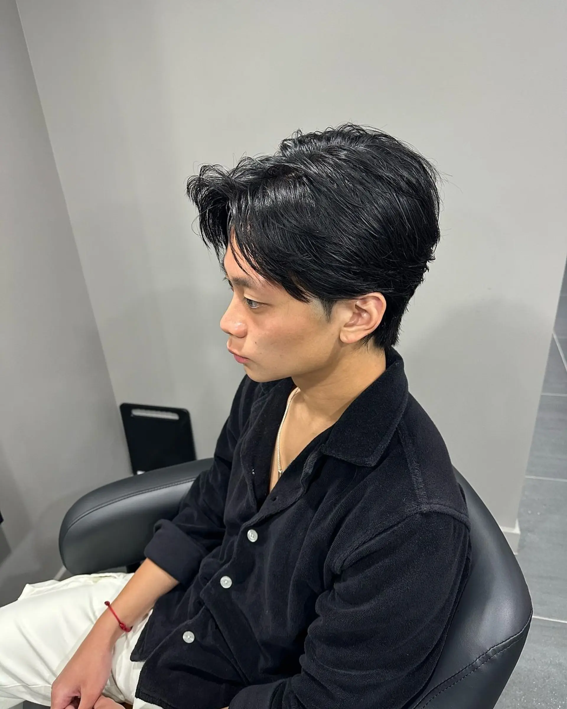 A contemporary classic hairstyle with a sleek tapered flow, featuring a side part and medium-length, straight black hair. The style is polished and refined with a glossy finish, giving off a stylish yet effortless vibe. 1