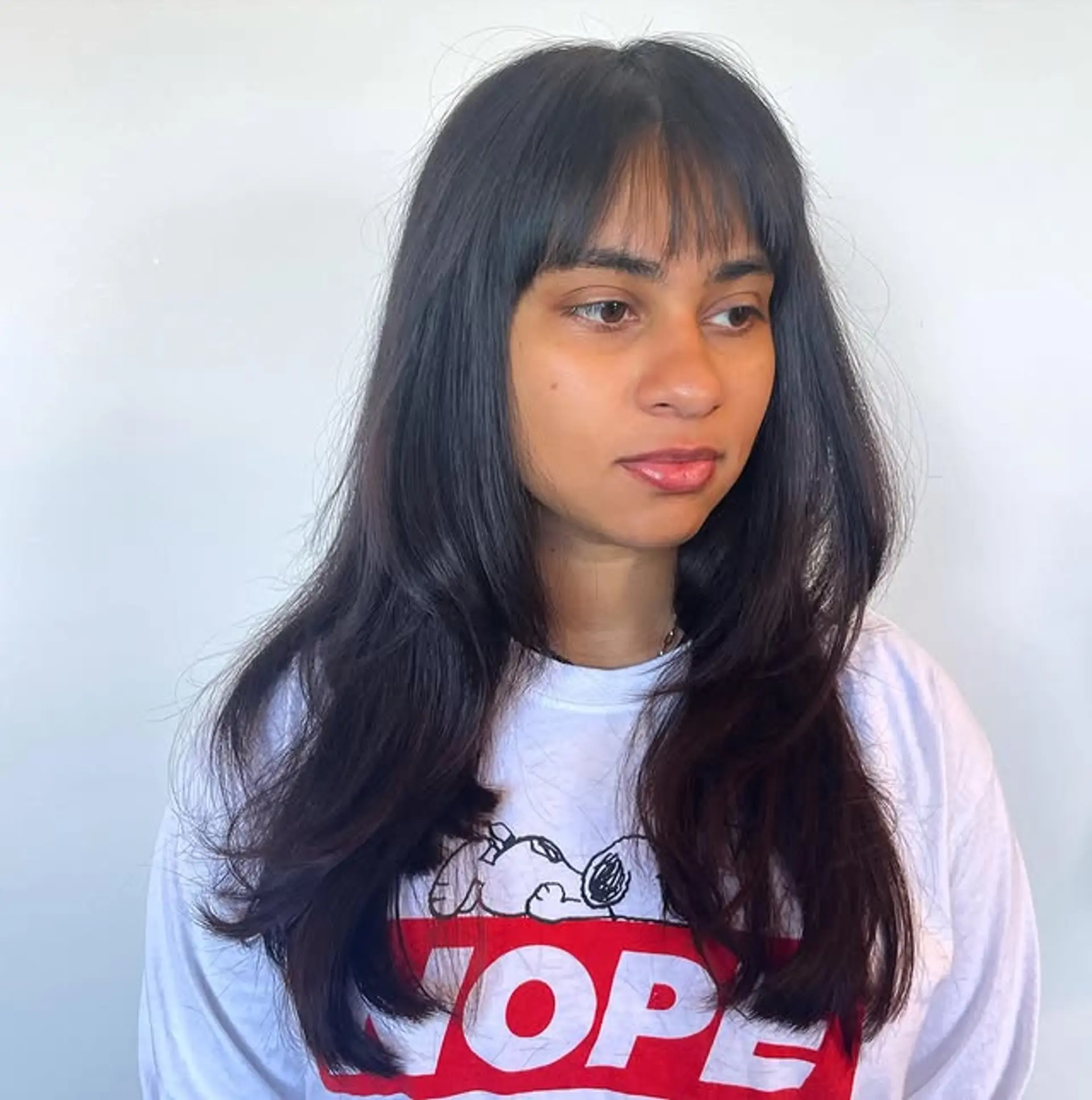 A layered long haircut featuring face-framing layers and Bardot bangs. 1