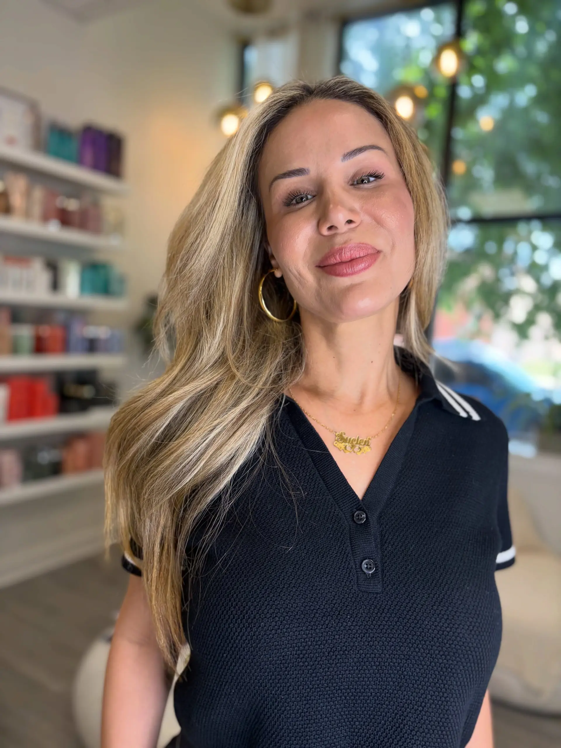 Long multi-tonal blonde hair styled into a smooth, voluminous blowout swept over the shoulder. 1