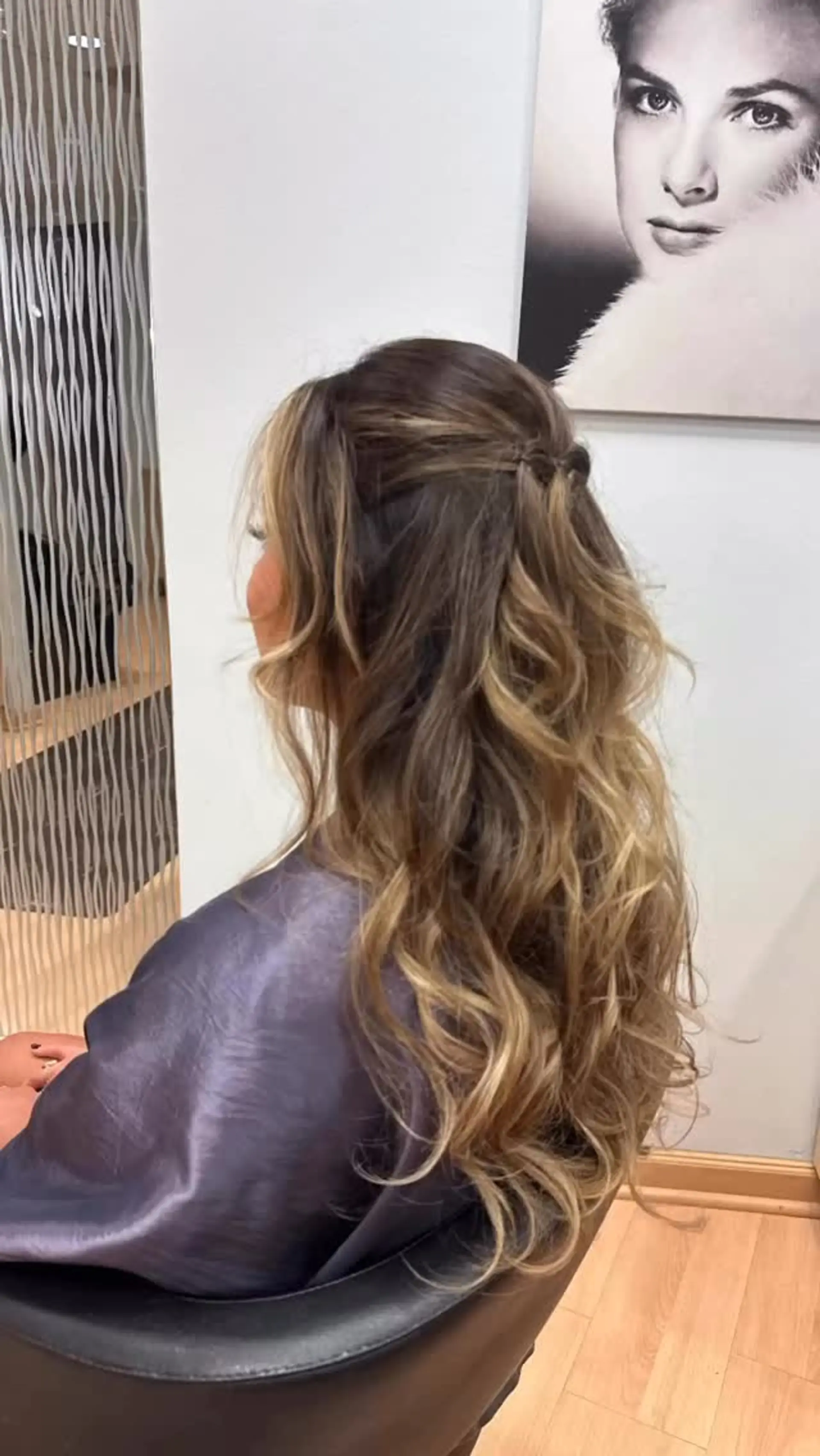 A romantic half-up half-down hairstyle featuring delicate crown pinning and cascading tousled waves. 1
