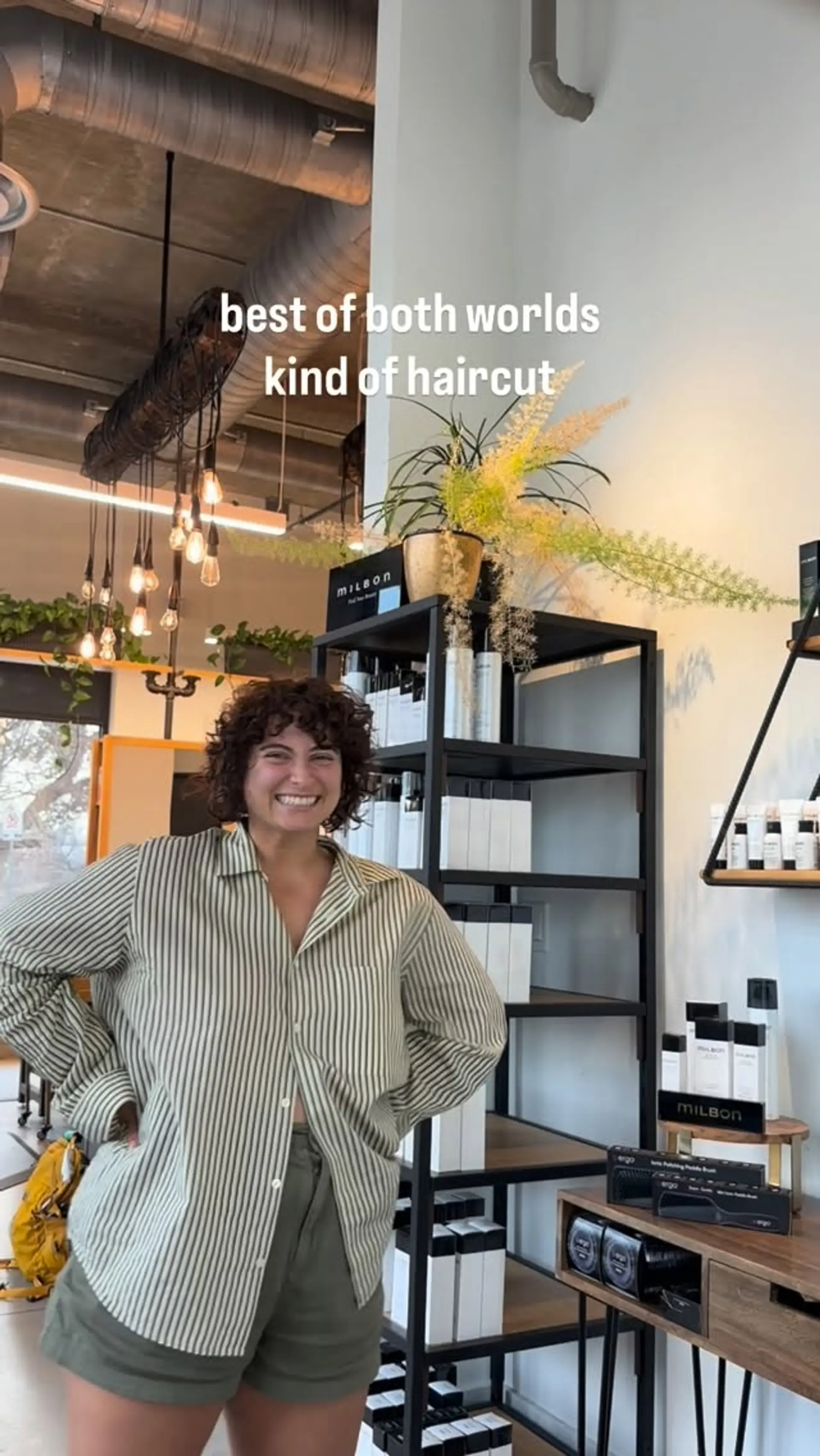 A short curly haircut with natural curl texture and full face-framing bangs. 1