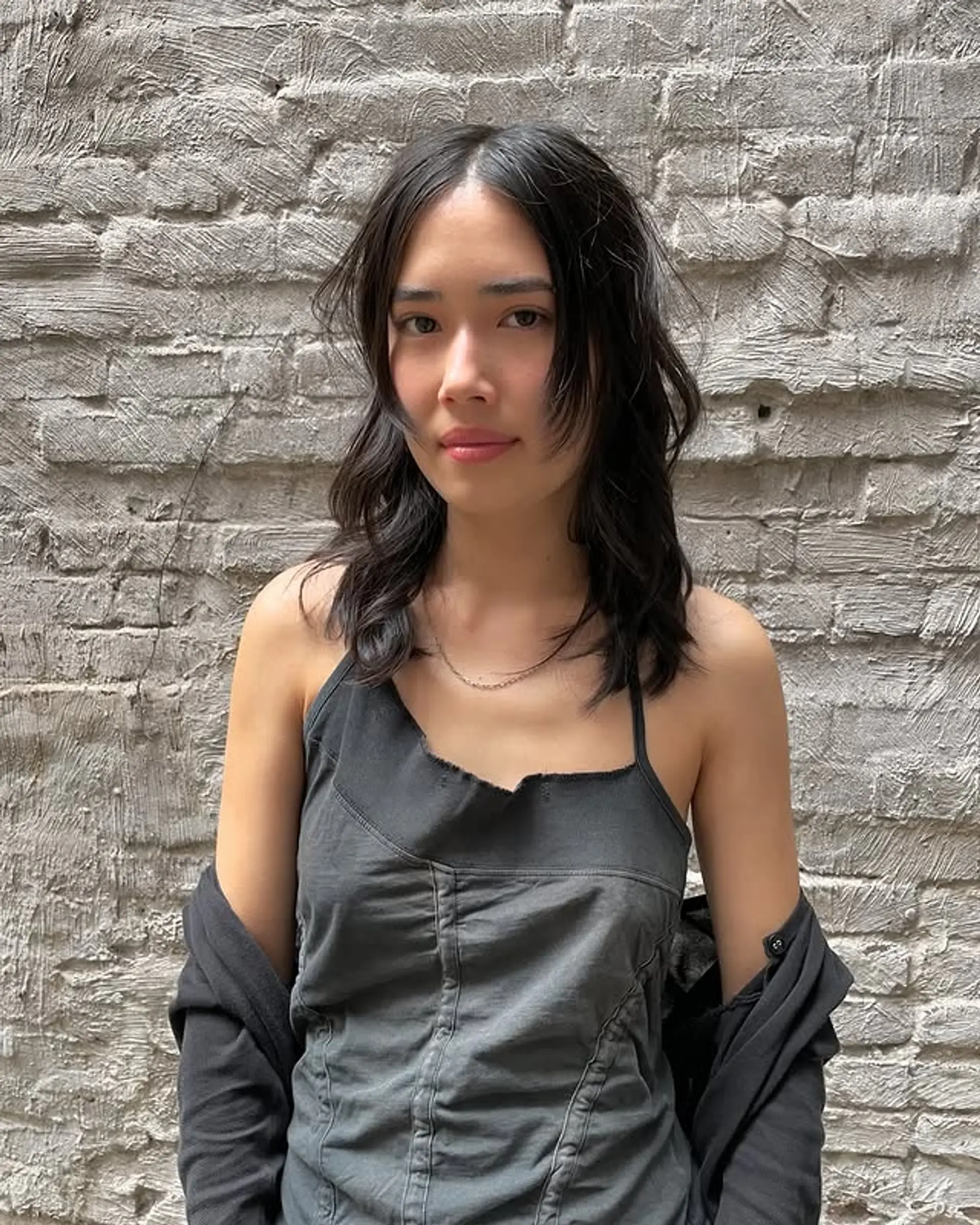 A medium-length shag haircut with layered waves and stylish curtain bangs. 1