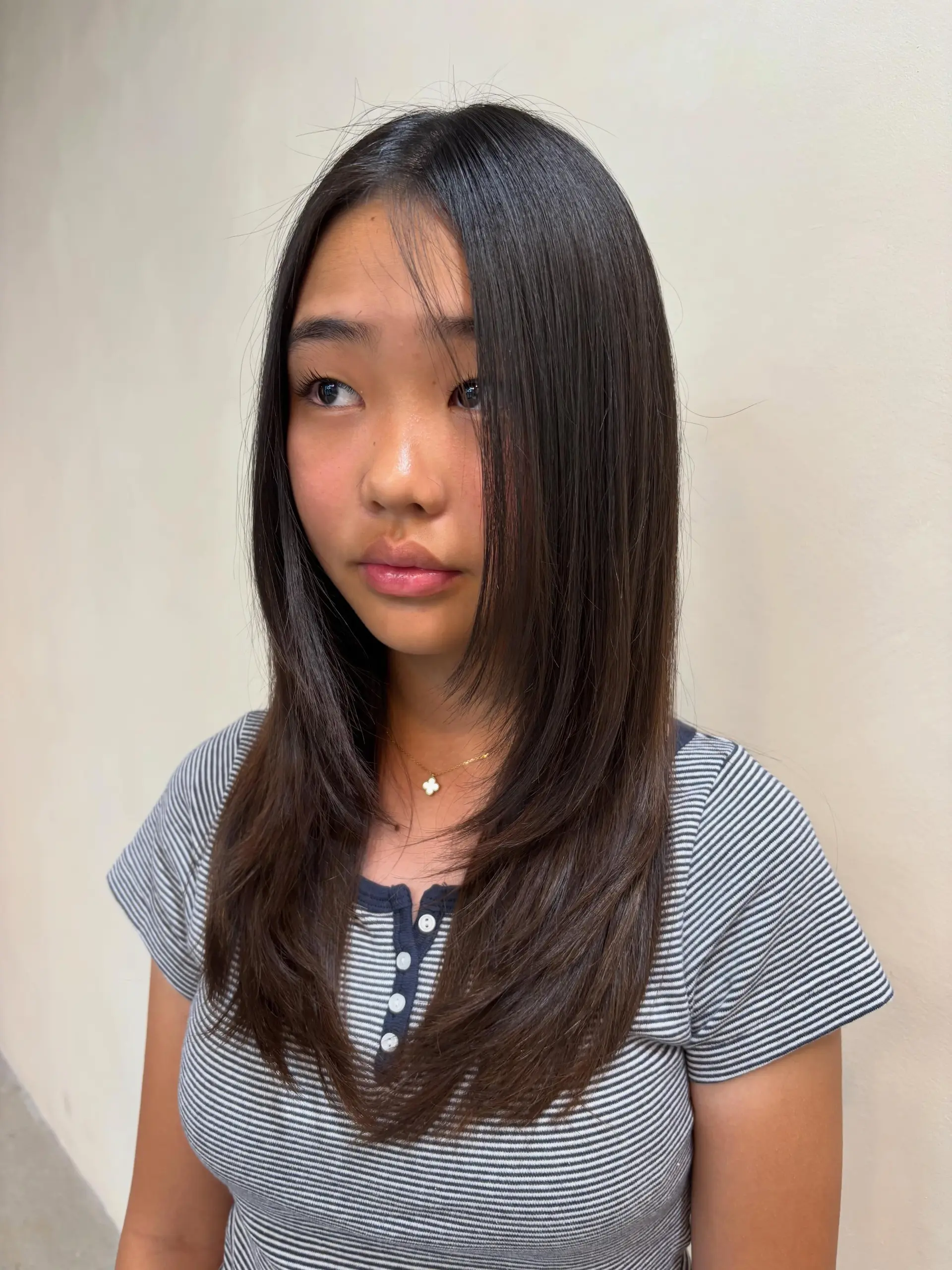 Long, sleek dark hair cut with smooth face-framing layers and soft, inward-curving ends. 1
