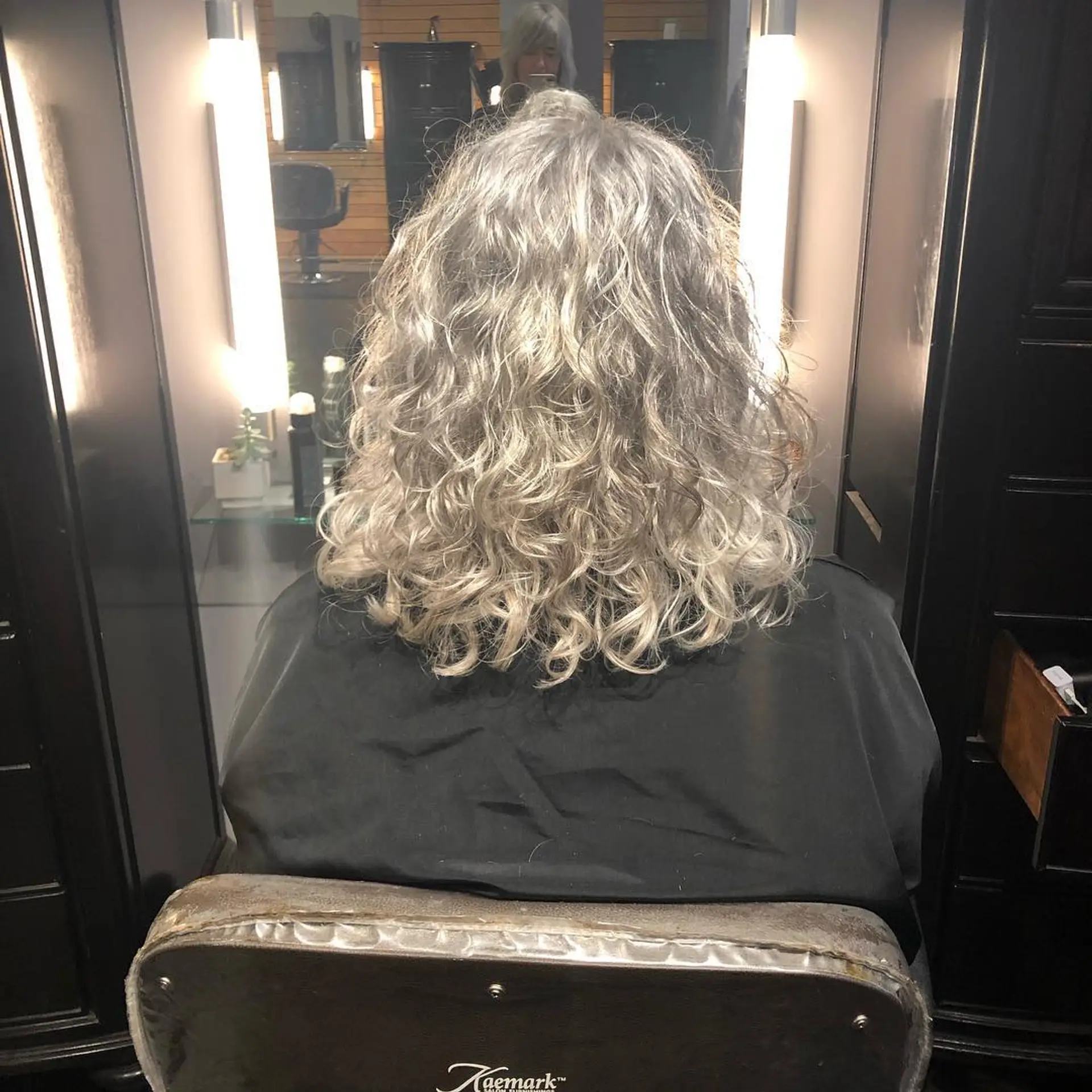 Medium-length defined curly gray hair with soft, bouncy spirals. 1