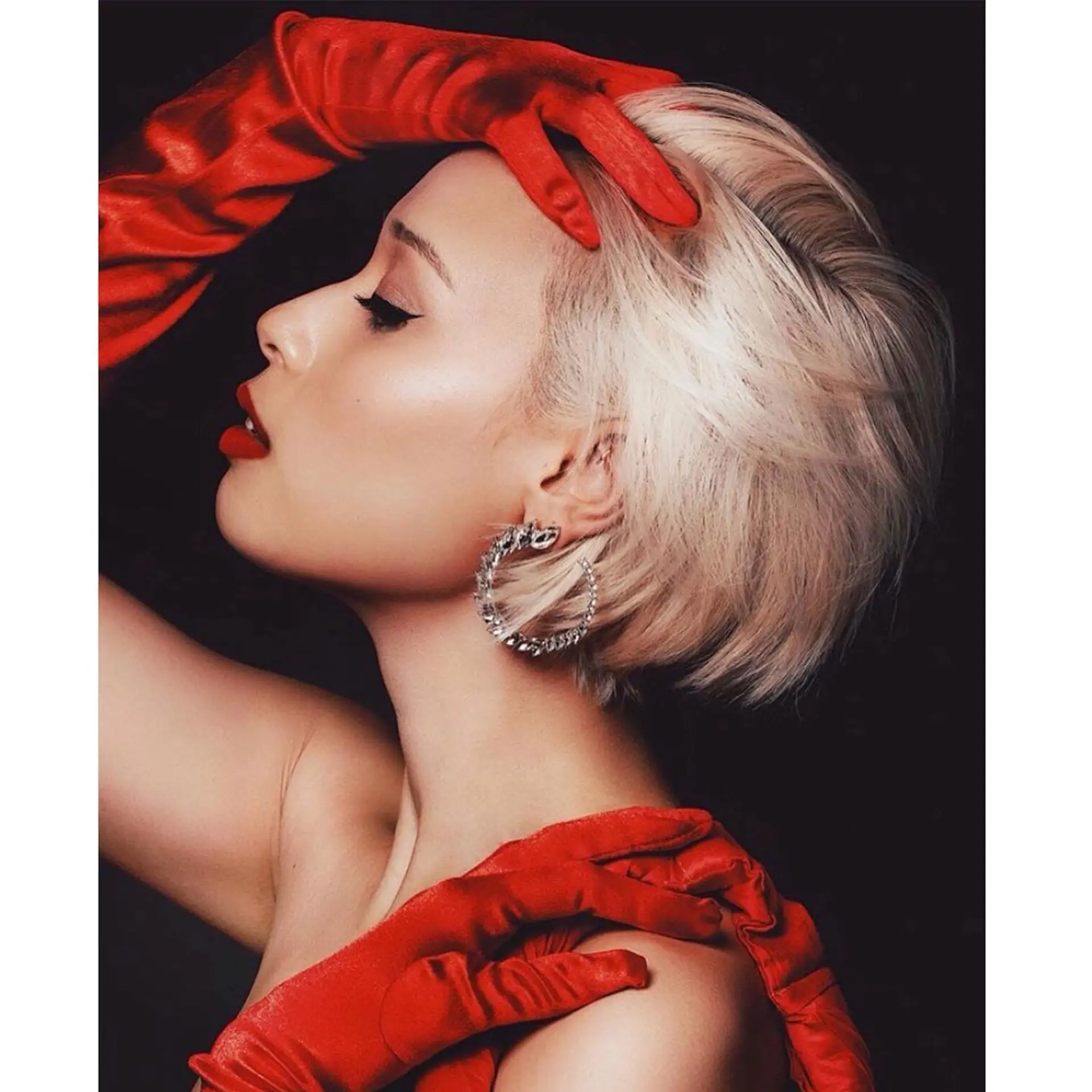 A voluminous platinum blonde bixie cut with textured, sweeping layers and tapered sides. 1