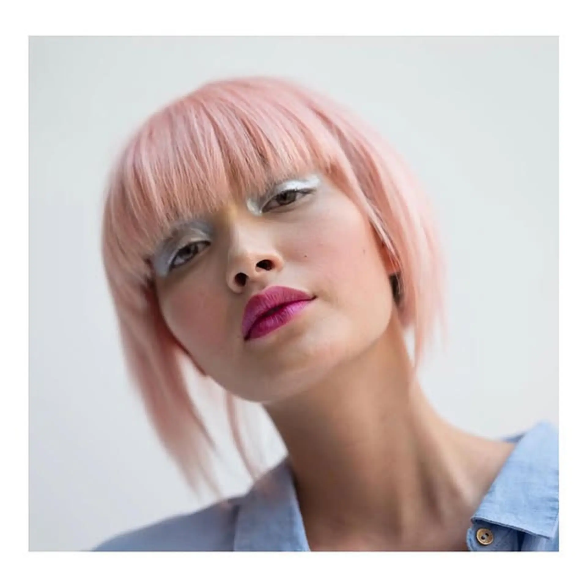 A stylish blunt bob with straight bangs in a vibrant bubblegum pink color. 1