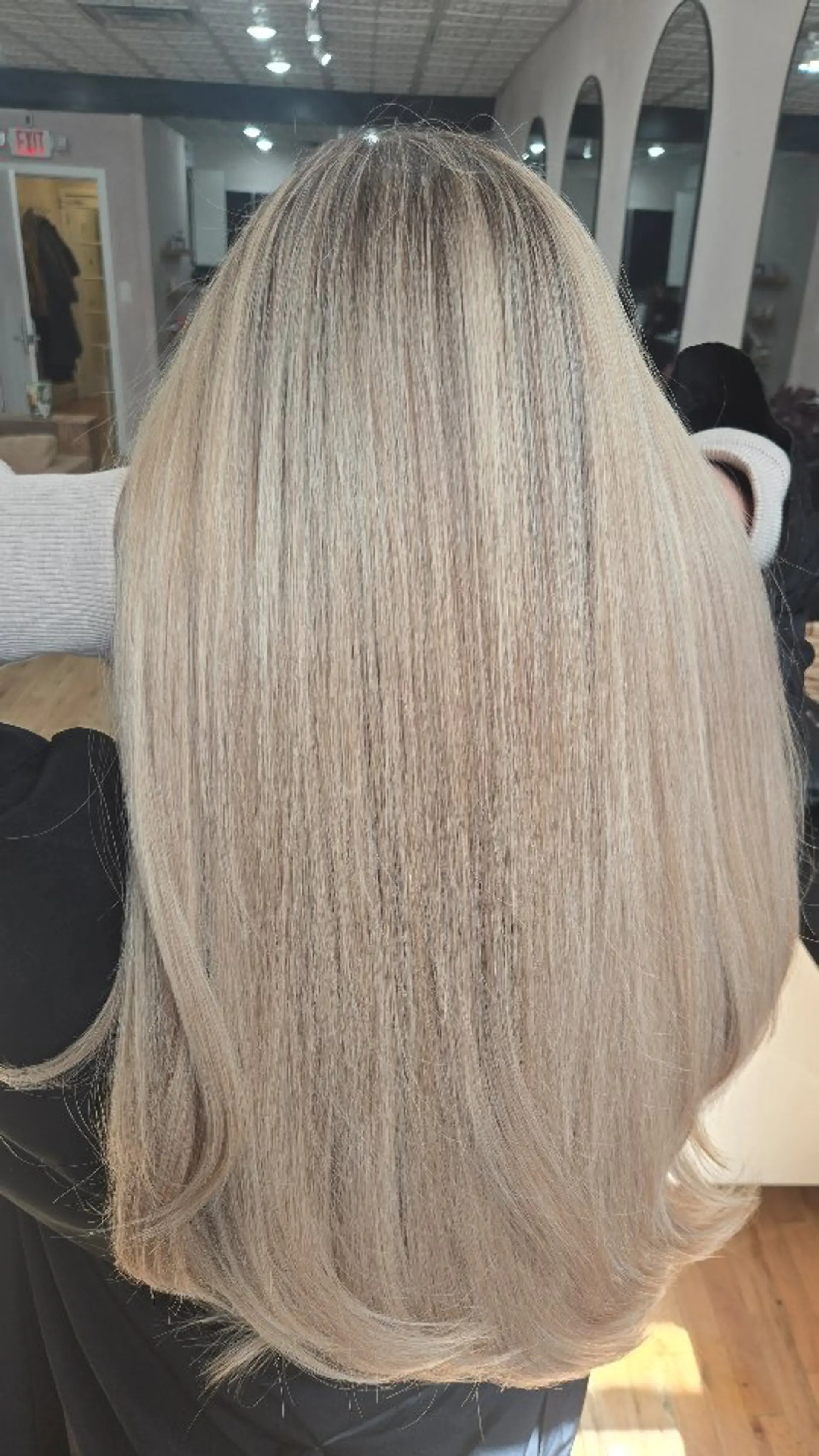 A long, seamless ash blonde hairstyle with smooth texture and soft, flipped-under ends. 1