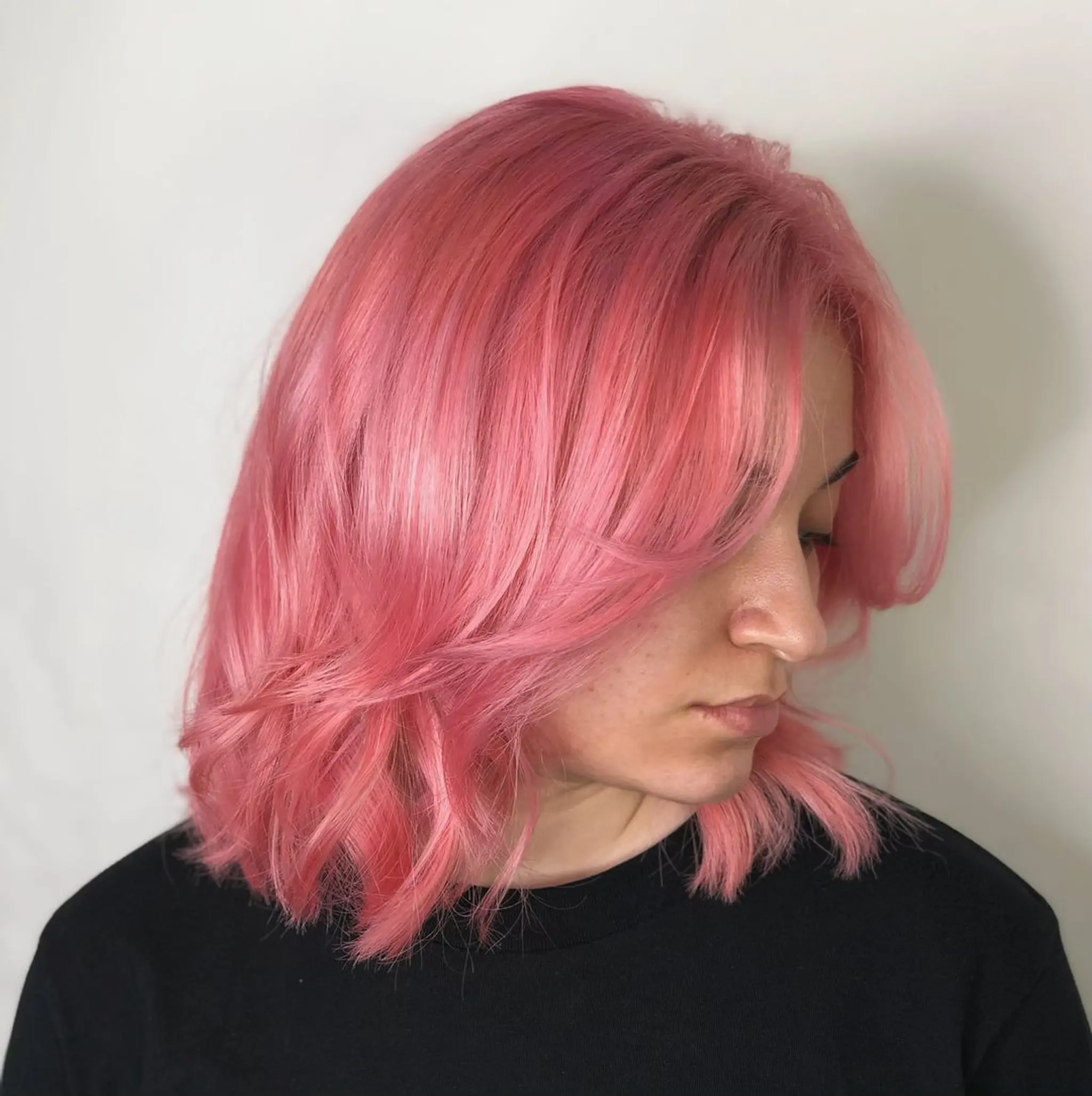 A medium-length, pastel pink wavy hairstyle with layers, a side part, and textured ends.
Stylist - @xcellent_jason