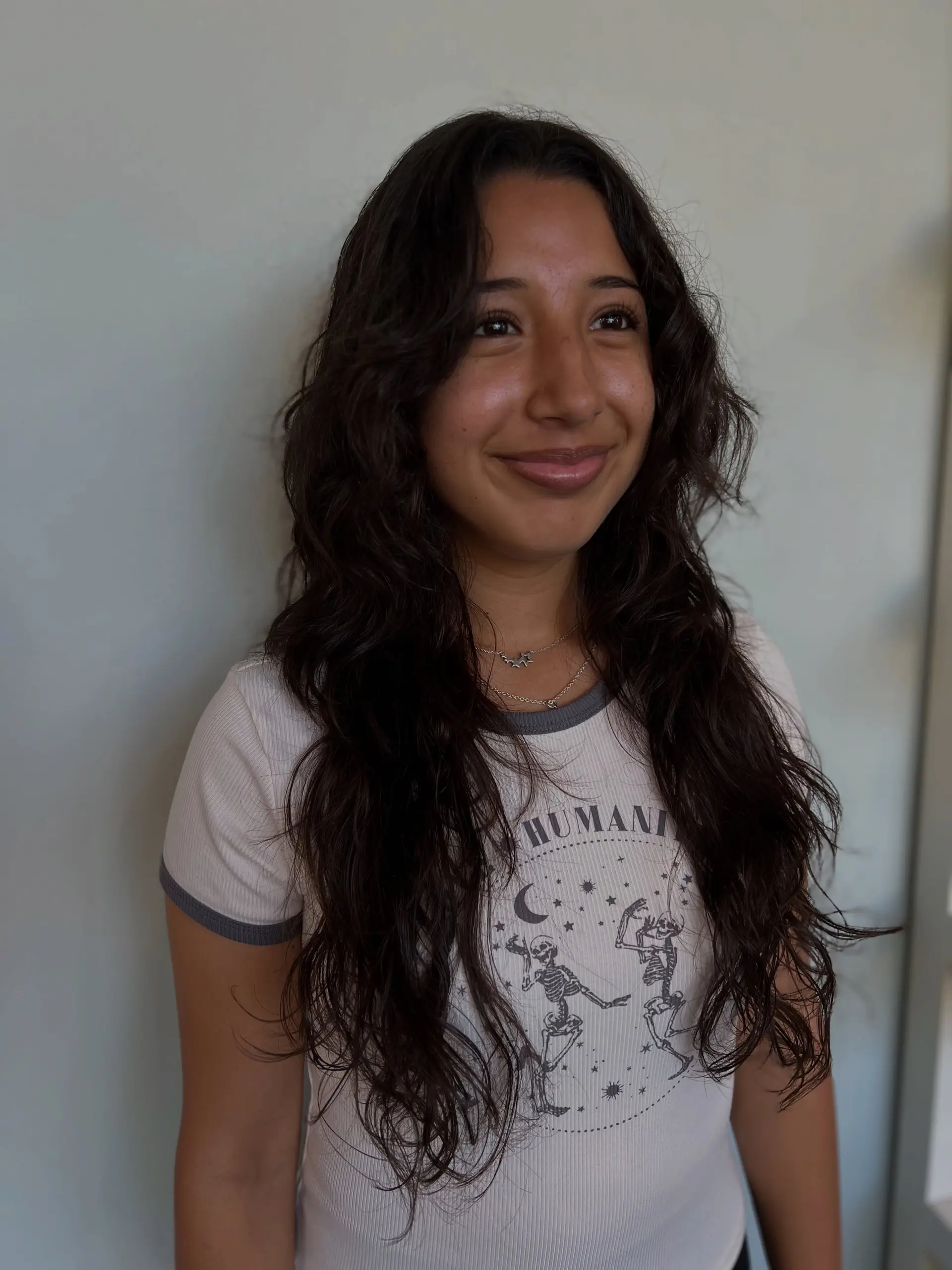 Long dark wavy-to-curly hair styled with textured layers and face-framing pieces. 1