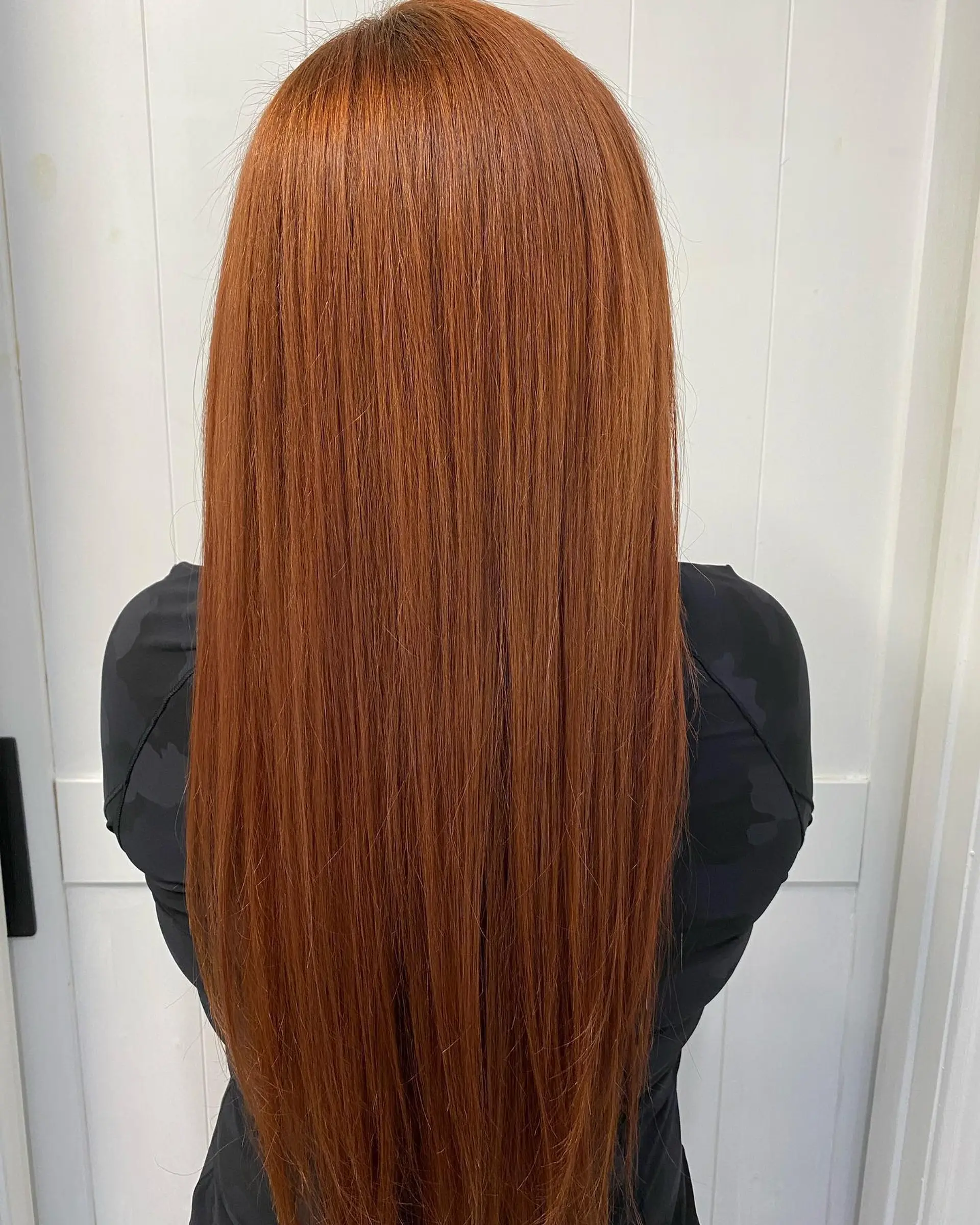 Ultra-long, vibrant copper-red hair styled silky smooth and poker straight down the back. 1