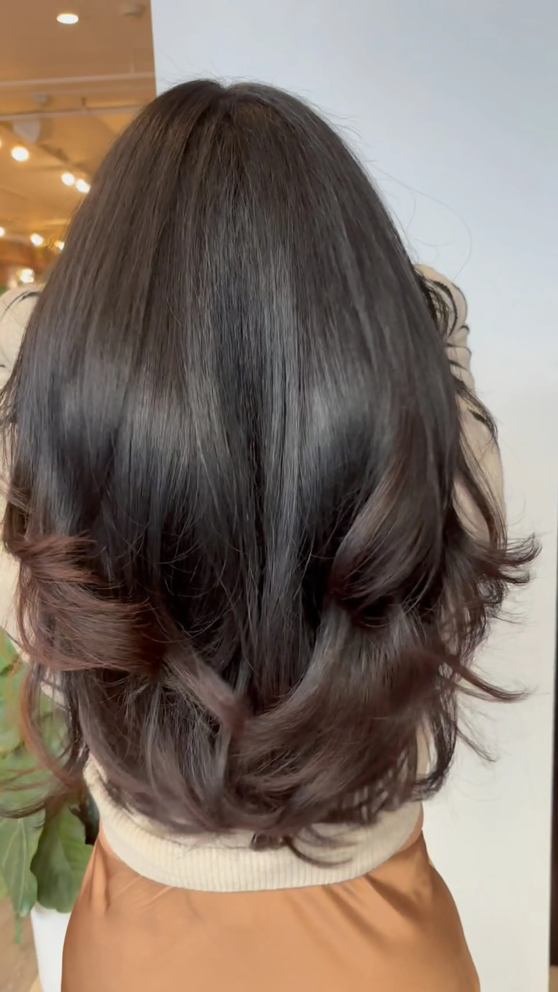 Medium-length dark brunette hair featuring seamless layers and a smooth, voluminous blowout with flipped and curled ends. 1