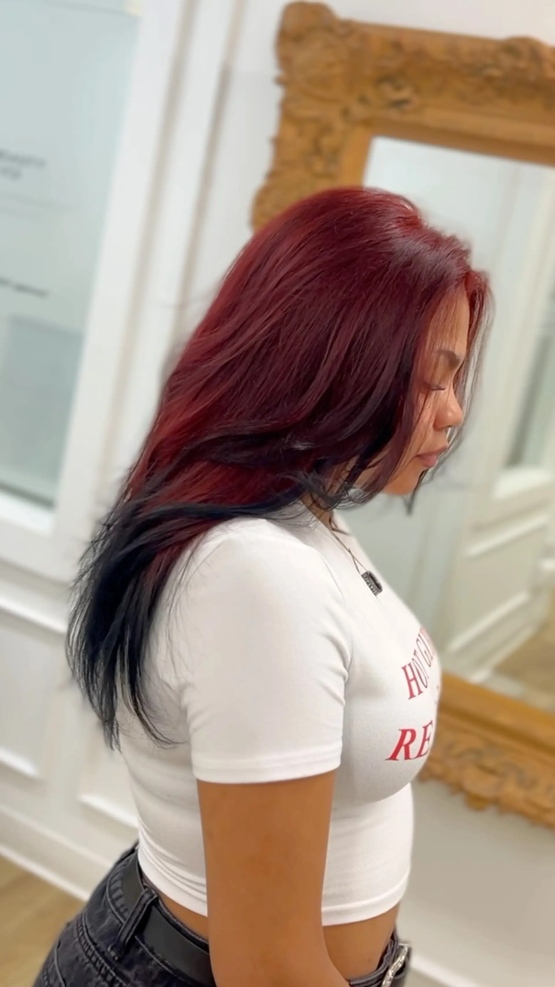 Long layered hair colored in a rich wine red tone accented with contrasting black ends. 1