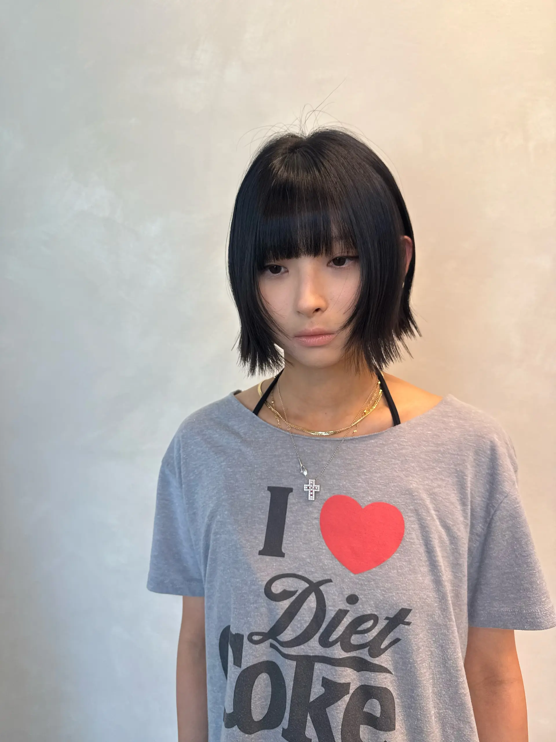 A textured short black bob cut with full, straight-across fringe bangs and face-framing layers. 1
