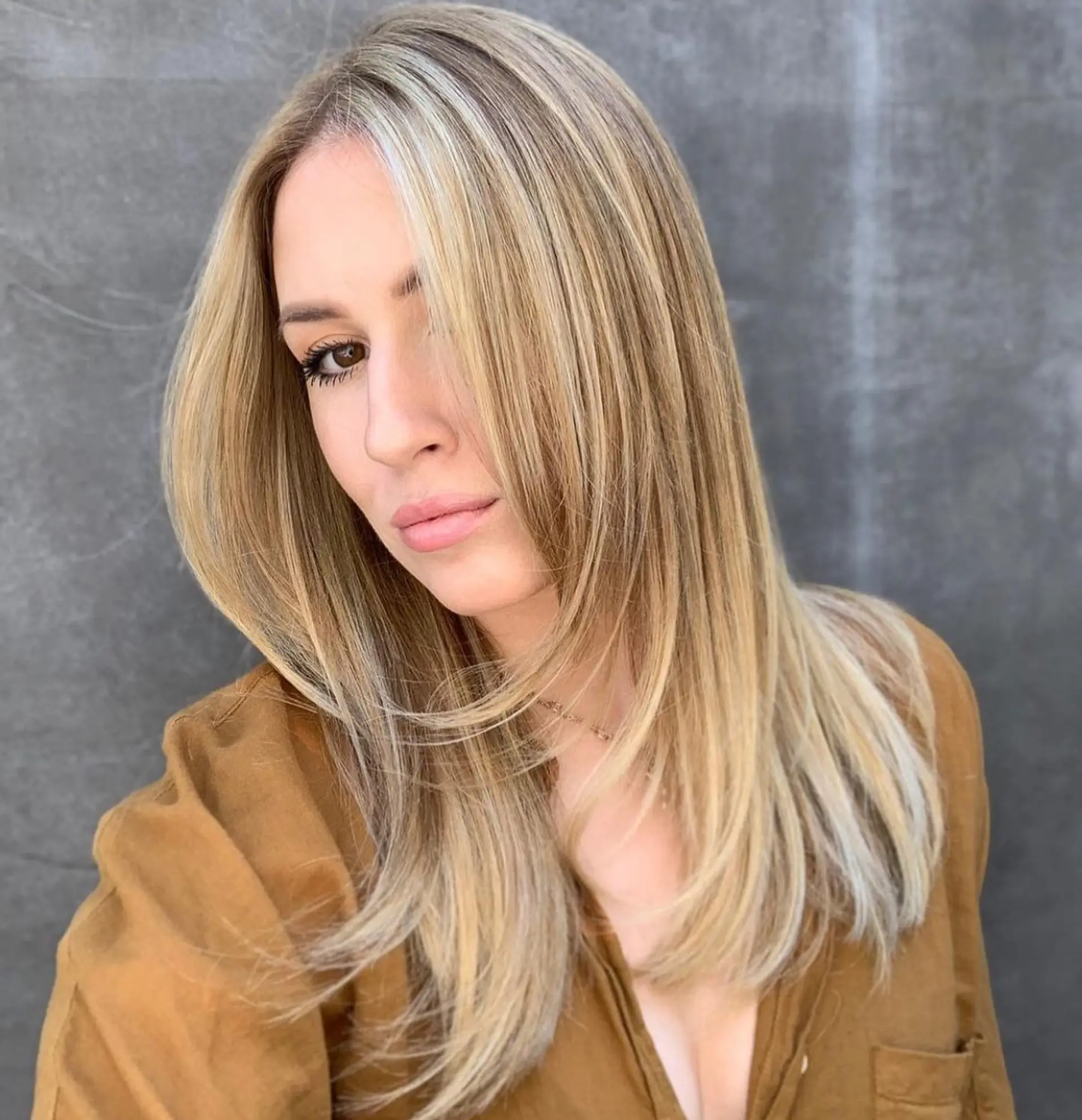 Long smooth blonde hair featuring a multi-dimensional balayage with bright face-framing pieces and soft interior layering. 1