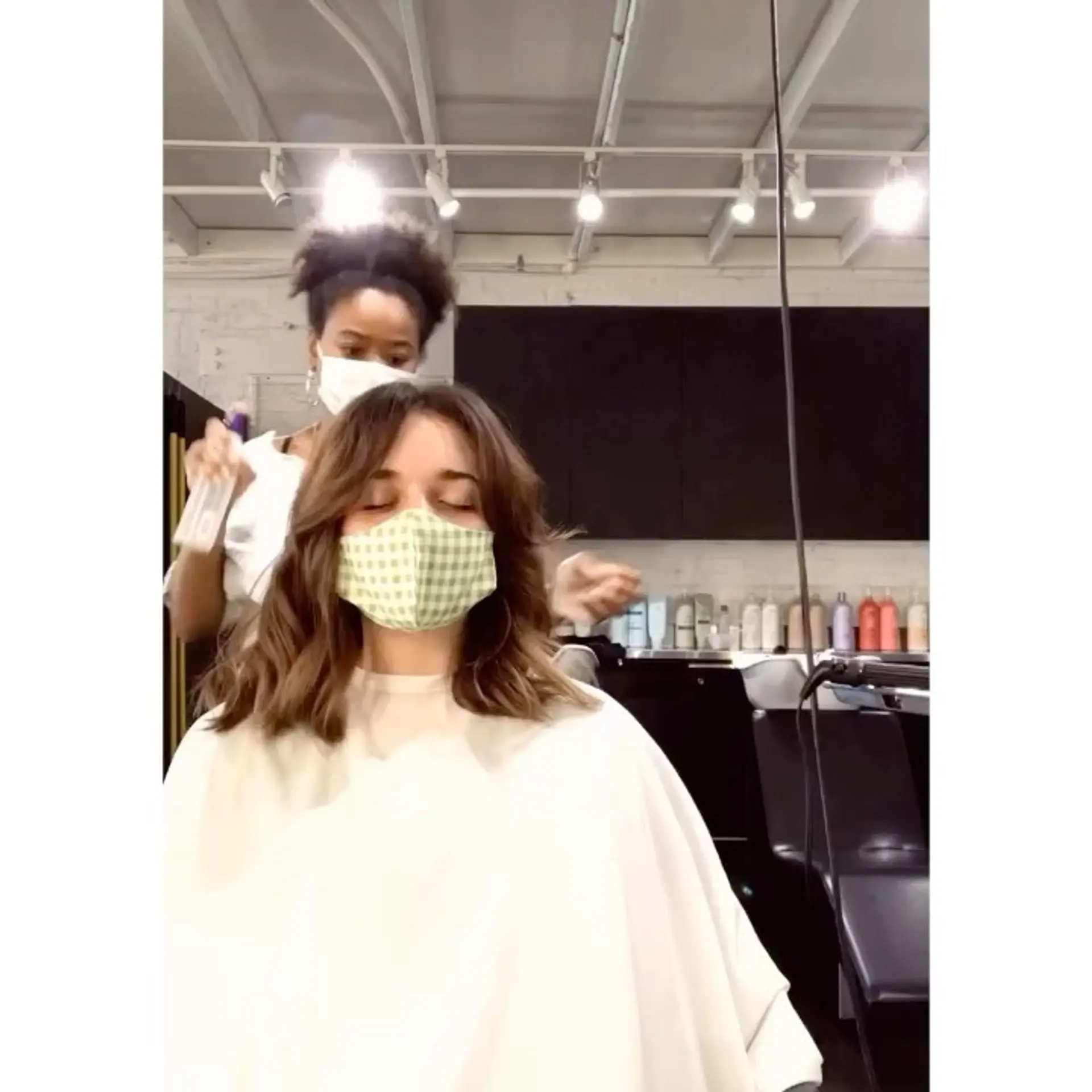A shoulder-length wavy brunette haircut featuring soft face-framing curtain bangs. 1