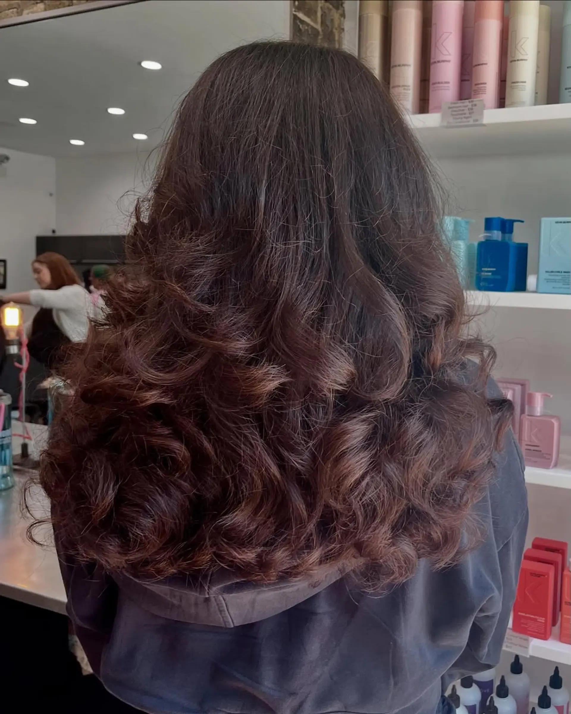 A long layered haircut with significant volume and bouncy waves, giving the hair a full and dynamic appearance with a soft finish. 2
