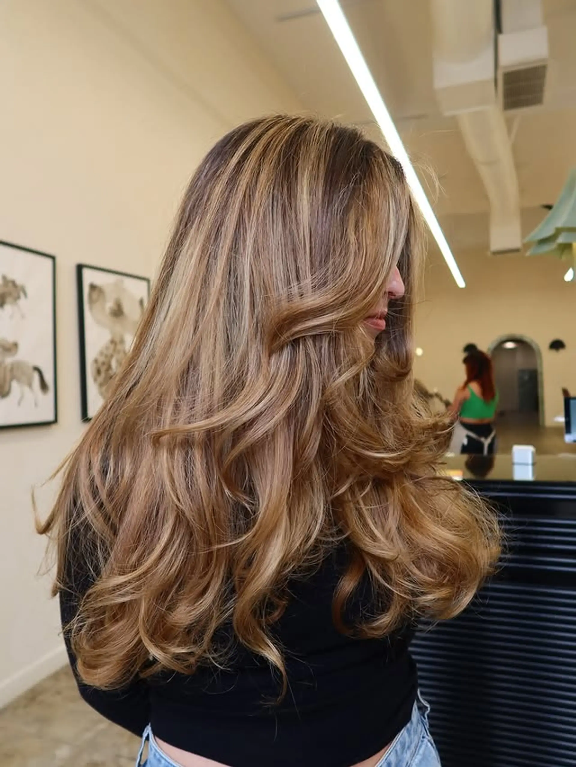 Long layered hair with a bronde balayage and voluminous waves. 1