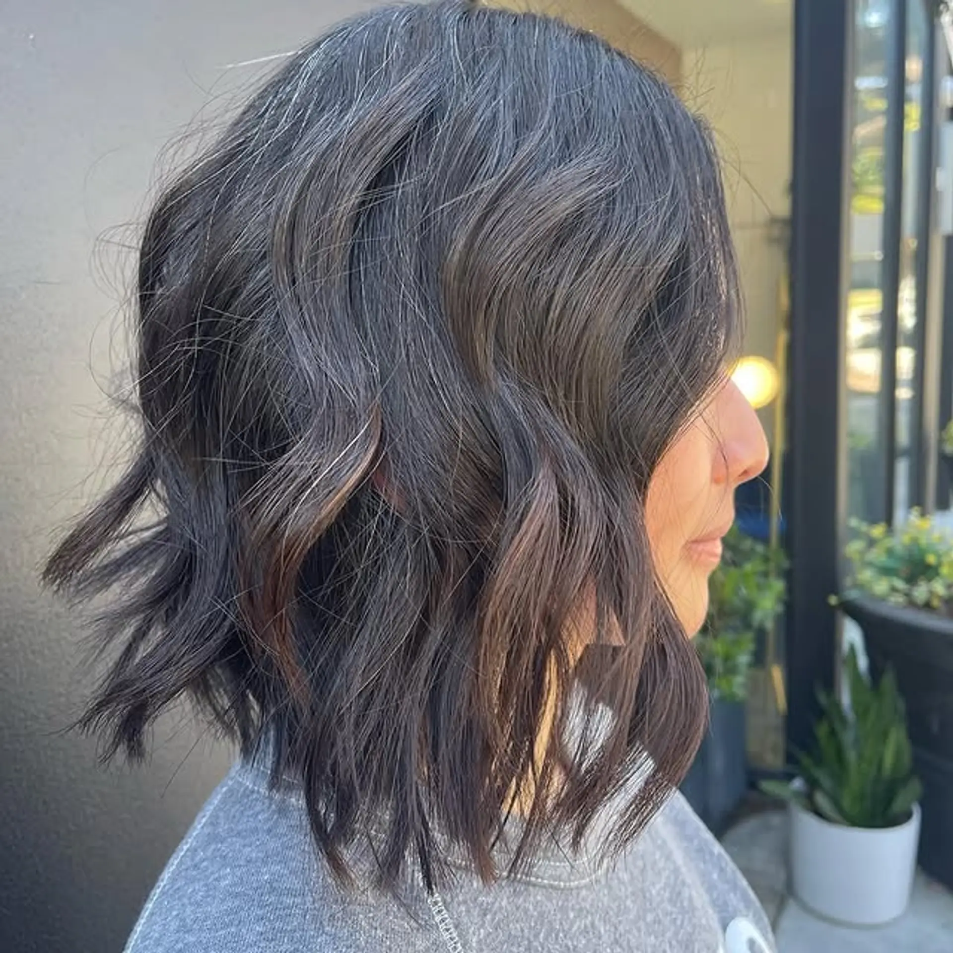 A medium-length wavy bob with bronde coloring and a subtle shadow root for added dimension. 1