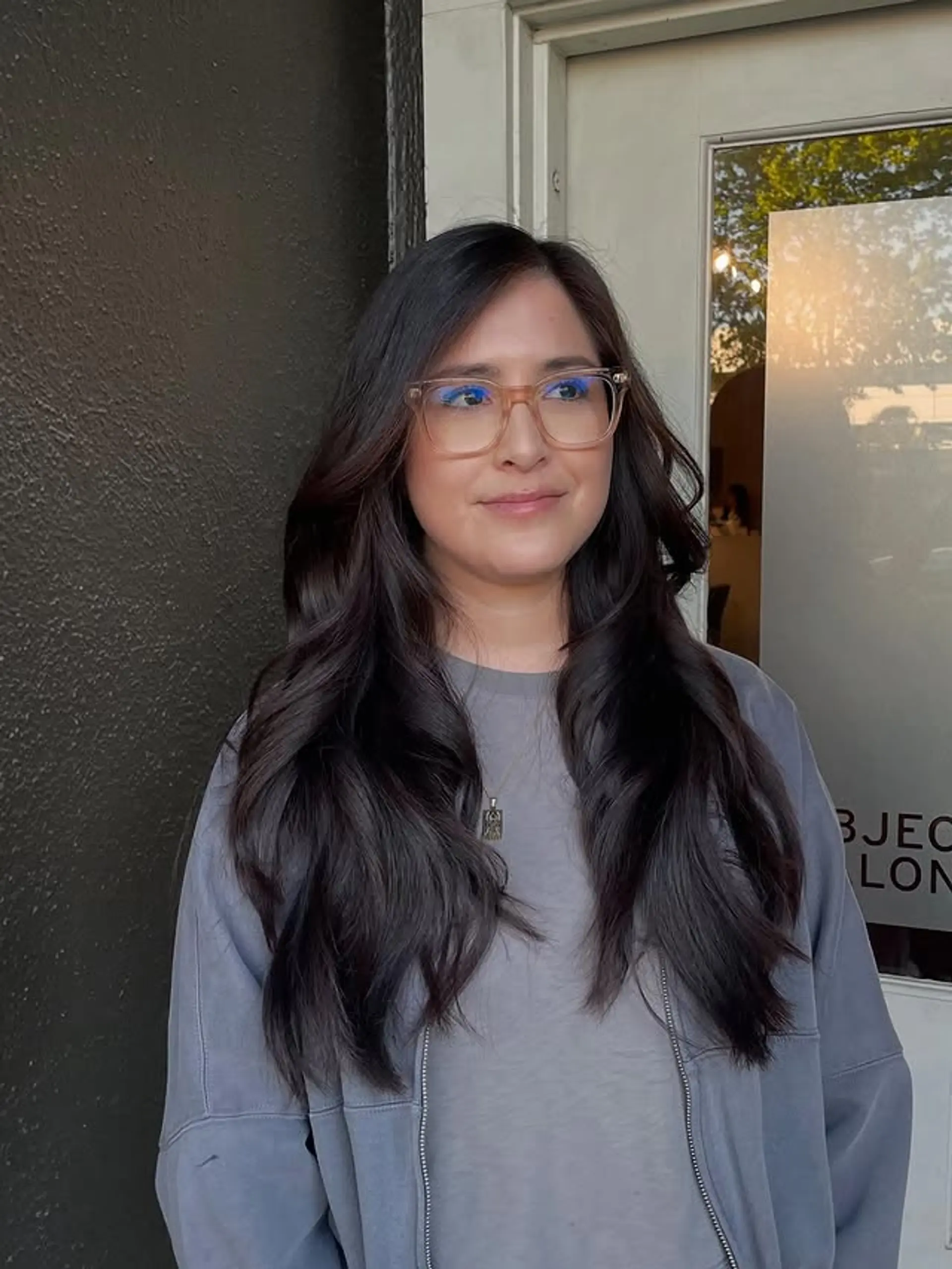 Long, layered hairstyle with soft waves and face-framing layers. 1